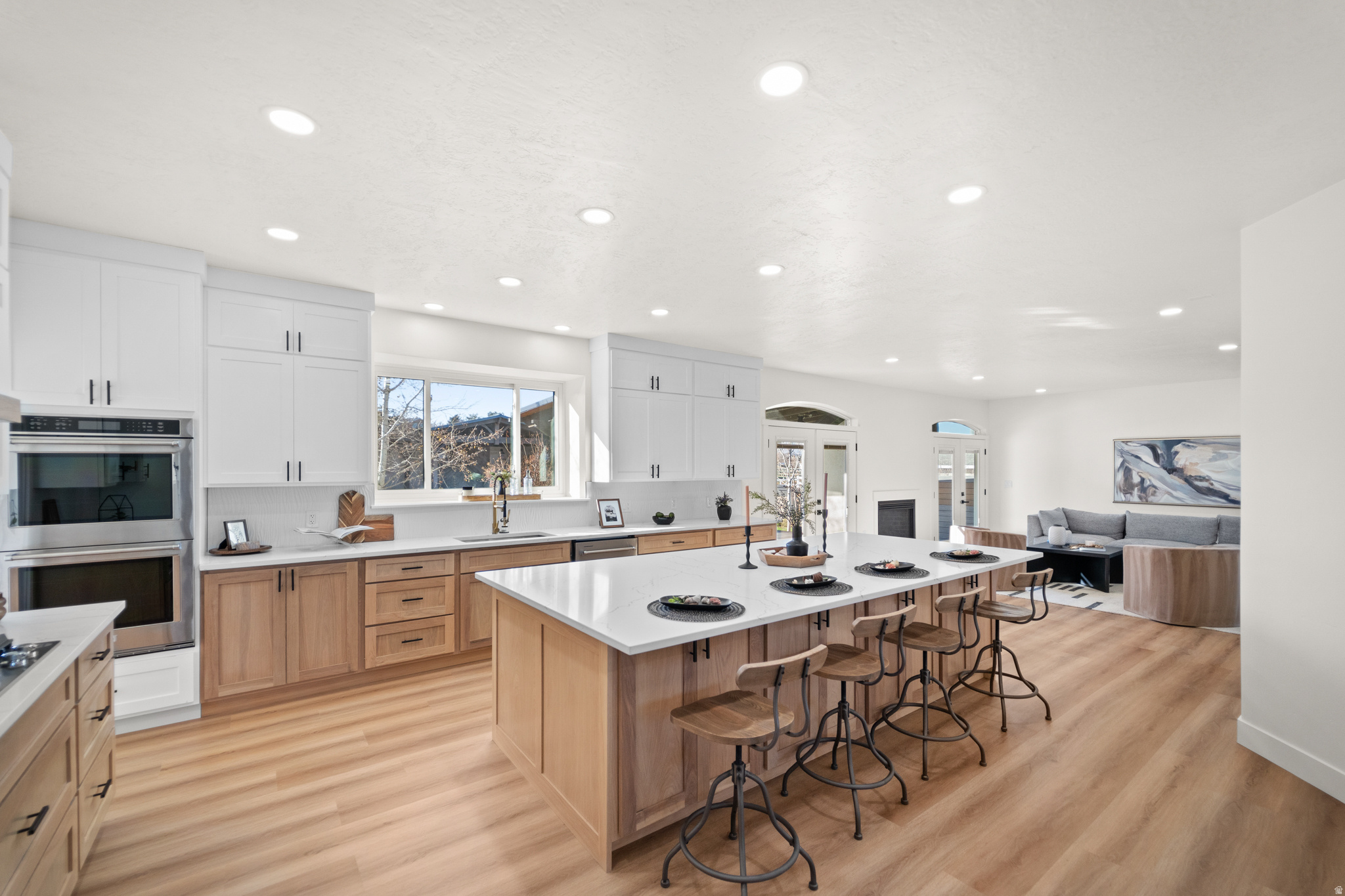 Welcome to an extraordinary modern-farmhouse residence, masterfully reimagined with sweeping views of the Wasatch Mountains. Completely remodeled with uncompromising attention to detail, this home showcases refined craftsmanship, timeless design, and resort-level amenities at every turn. A sweeping wraparound covered front porch sets a gracious tone, offering a front-row seat to peaceful mornings and unforgettable mountain sunsets. Inside, the home unfolds into light-filled living spaces anchored by a striking living room with oversized new windows, creating an atmosphere of warmth, elegance, and effortless comfort. The heart of the home is the chef's kitchen-designed to impress and perform-featuring custom two-tone cabinetry, quartz countertops, a grand statement island, pot filler, double ovens, stainless steel appliances, and abundant storage. Updated LED lighting throughout enhances the home's clean lines and sophisticated finishes. The primary suite is a true private retreat, offering generous space, and a grand custom bathroom suite complete with glass-enclosed shower doors, upscale finishes, and an expansive walk-in closet designed for luxury living. Outdoors, the property transforms into a private resort. A newly constructed heated in-ground saltwater pool with cascading waterfall features and multi-level lounging areas creates a stunning focal point, complemented by a chic pool house ideal for entertaining or relaxing. Two covered decks provide ample space for gatherings, while low-maintenance turf grass, an in-ground trampoline, and a private basketball court with custom lighting elevate both form and function. Zoned for (4) horses, this property offers a rare opportunity to blend refined living with equestrian potential, adding versatility and long-term value to an already exceptional setting. For the collector, entrepreneur, or enthusiast, the impressive 15-car heated and air-conditioned garage and shop is unparalleled, featuring massive automatic doors and expansive concrete space ideal for oversized vehicles, business use, or luxury storage.Garage measures 100 feet long, 32 feet wide, and approximately 17 feet high, and features 14-foot doors. Additional RV parking adds further versatility. This is more than a home-it is a lifestyle property where modern sophistication meets refined rural charm. Every element has been thoughtfully curated to offer privacy, luxury, and enduring value in a setting that is as functional as it is breathtaking.  Square footage figures are provided as a courtesy estimate only and were obtained from county record. Buyer is advised to obtain an independent measurement.