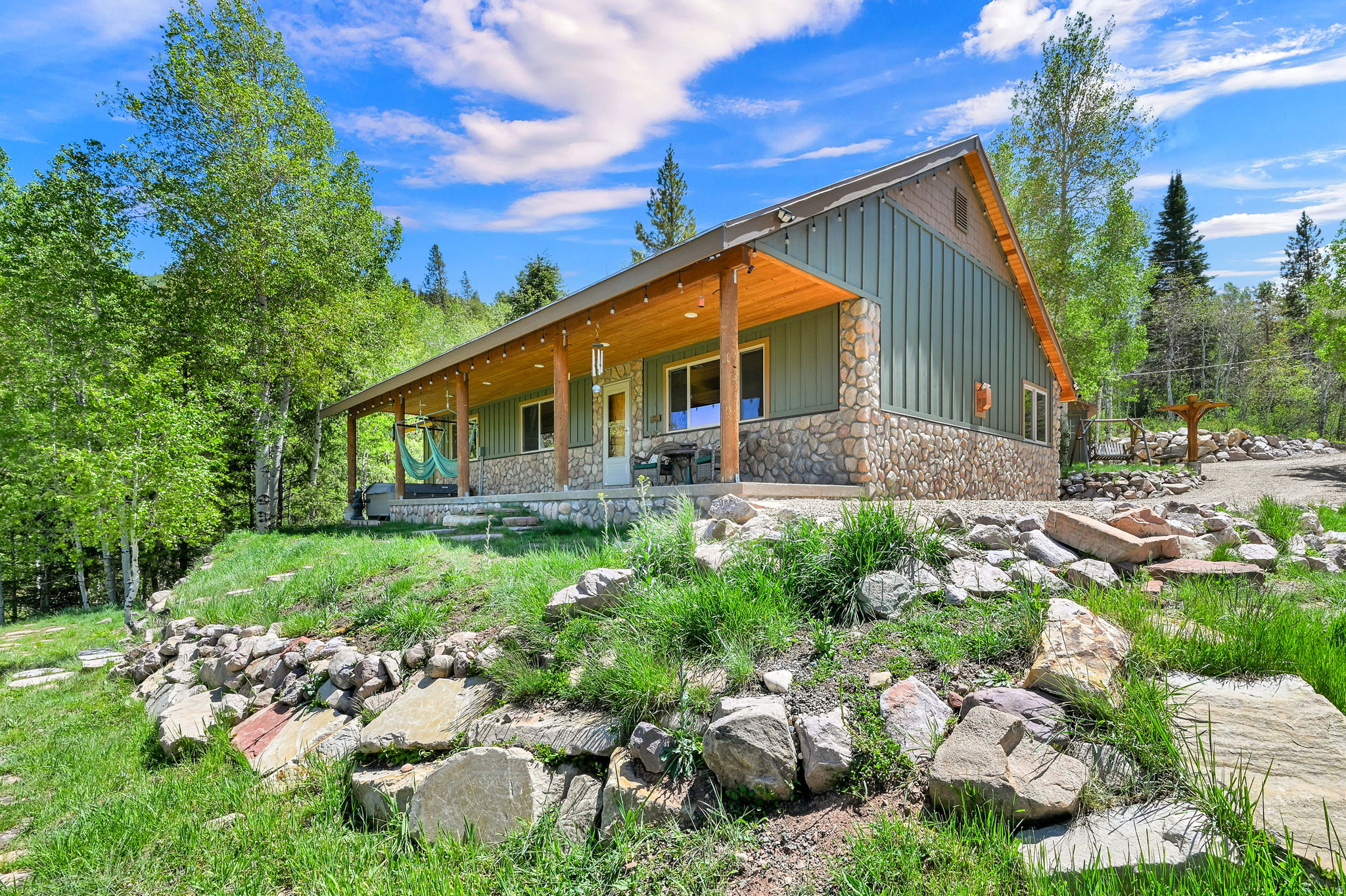 Escape to your own private mountain retreat in Weber Canyon, where year-round access meets unmatched natural beauty. Located just 25 minutes from Park City and 40 minutes from Salt Lake City, this stunning 1.45-acre property offers the perfect balance of seclusion and convenience. Perched above the Weber River in Oakley's coveted Hidden Lakes community, this 3-bedroom, 3-bathroom home captures breathtaking panoramic views of the river, wetlands, mountains, and surrounding hillsides. Designed for effortless living, the open-concept floor plan flows seamlessly to four separate patios, each offering a unique vantage point to soak in the scenery. The detached 3-car garage and toy barn is an entertainer's dream, featuring a projector movie system, surround sound, and a wet bar for hosting family and friends. Two heated bunkhouses provide additional accommodations for guests and create the ultimate mountain getaway experience. Just a short drive or hike through a grove of quaking aspens, you'll find the community's private lake-perfect for kayaking, paddle boarding, fishing, or relaxing lakeside with a picnic. Endless hiking and outdoor recreation begin right outside your door, while evenings are best spent unwinding in the hot tub as snow gently falls across the valley. Whether you're seeking a full-time residence, weekend escape, or recreational haven, this extraordinary property offers a lifestyle few ever get to experience.