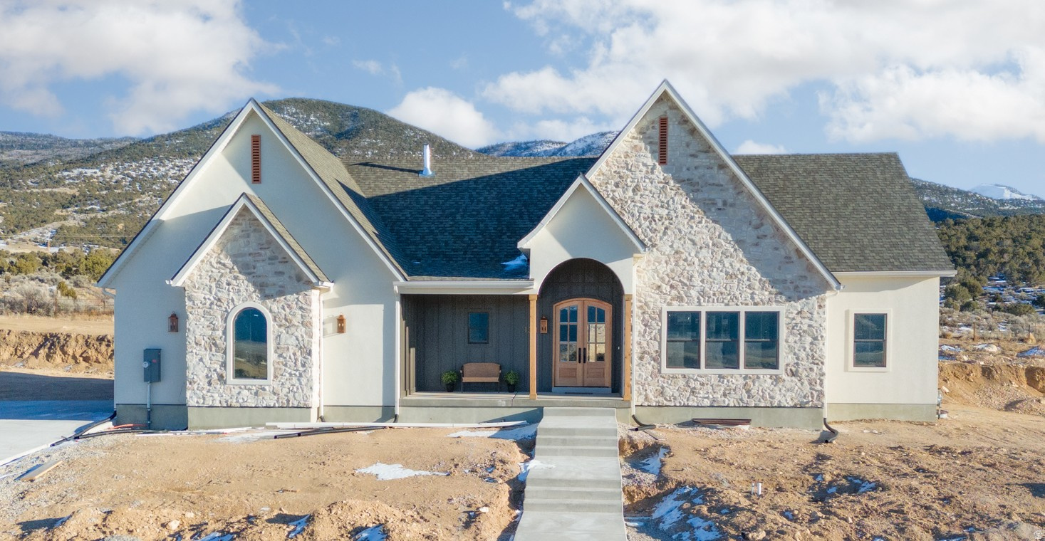 Step through the arched double doors and you'll immediately feel the thoughtful European-inspired design that sets this Manti Crystal Springs Model home apart. Vaulted ceilings, arches throughout and a seamless layout help create this timeless feel. The kitchen blends style and function with little touches like the pot filler or the oversized pantry next to the hidden coffee bar that really take form and function to the next level. The Primary Suite is your own private retreat continuing the vaulted ceilings leading into the spa inspired bathroom with separate vanities, walk in shower, a chandelier over the soaking tub leading to the large walk-in closet. The unfinished basement already has a roughed in kitchen and bathroom for an income generating separate apartment with its own entrance or additional living space. A water share is included as well as front yard landscaping and is scheduled to be completed this spring. Seller financing available for qualified buyers, NO HOA.