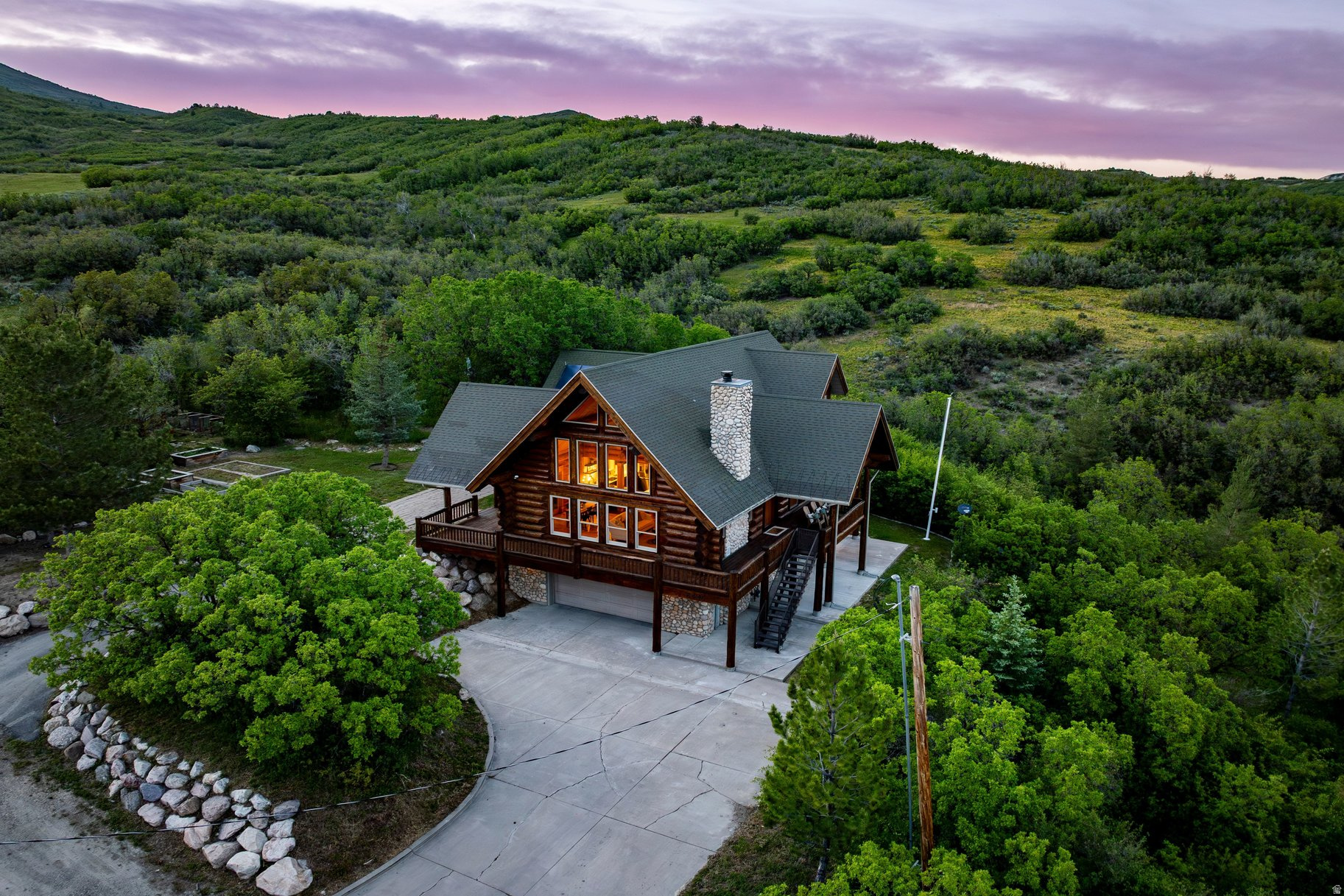 Mountain living at its finest. Set on 1.27 private acres against the mountainside in Mountain Green, this beautifully remodeled log home offers unobstructed views, exceptional privacy, and a setting that feels deeply connected to nature. Extensive improvements include renovated kitchen and bathrooms, restored hickory hardwood flooring, new flooring, fresh paint, updated trim, and professionally selected finishes throughout. Significant investment has been made in preserving the home, including professional restoration of the imported log exterior with refinishing, staining, sealing, and replacement of the chinking. Expansive views of Wasatch Peaks and Snowbasin are enjoyed from the near wraparound deck and main living spaces. The home features a main level primary suite, main level laundry, separate basement entrance, wood burning fireplace, and central air conditioning and forced air heating on the main and lower levels. Additional property amenities include RV hookups with dedicated power, water, and sewer connections. Frequent wildlife sightings, abundant outdoor recreation, and close proximity to Snowbasin Resort, Wasatch Peaks Ski Resort, Pineview Reservoir, and everyday conveniences make this an exceptional opportunity for a primary residence, mountain retreat, or second home. Some properties simply need to be experienced in person to be fully appreciated.