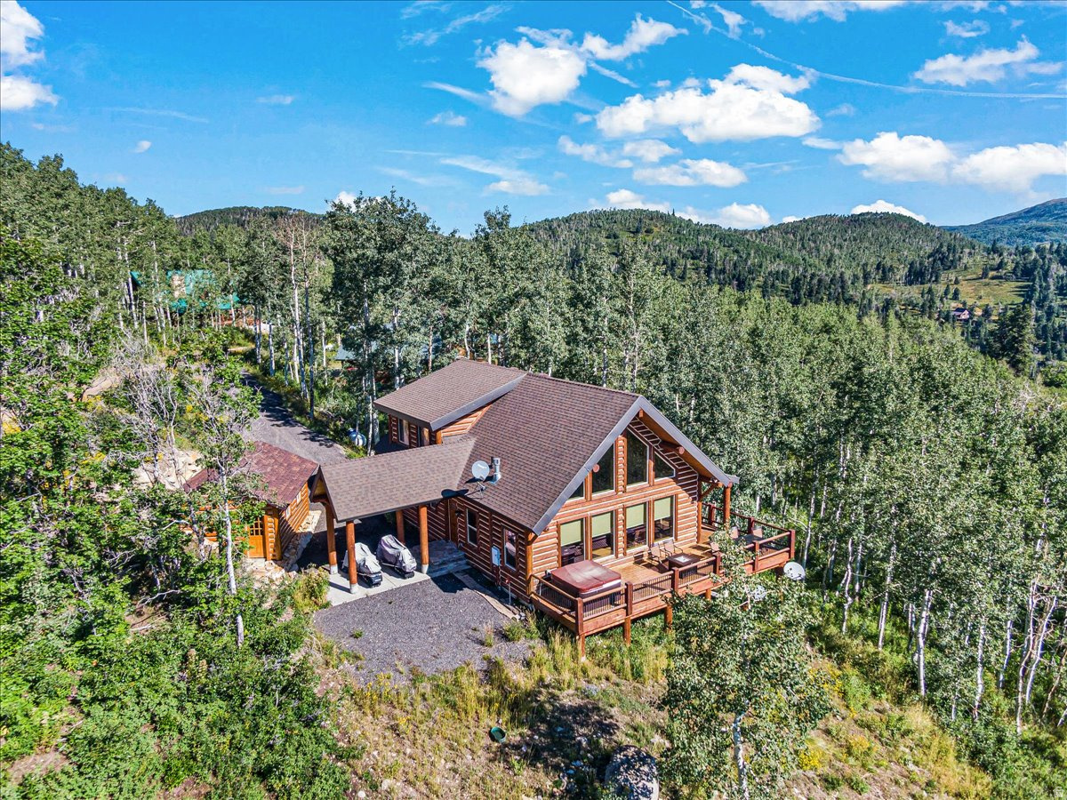 Almost Heaven! When you dream of a cabin in the woods--this is what comes to mind.  Forever views (check) tree lined ridges (check) log home with a fireplace (check) room for my toys (check) wrap around decks and outdoor grill (check) meandering moose, deer, elk and more at your backdoor (check) light filled rooms (check)  blue skies with eagles and hawks (check) and best of all...oh so quiet (check). At the tippy top of Tollgate Canyon you will find this impeccably maintained, custom-built cabin nestled among lush aspen groves and abundant pines.  The finest of finishes include Kraftmaid cabinets, granite countertops, hardwood floors, jetted tub, wrought iron chandelier, primary suite with separate tub shower, vaulted wood and beamed ceilings and lower level walk out. There is plenty of room for your family and friends to spread out and enjoy the lower level family/game room, four guest rooms and massive outdoor decks.  This one is special!