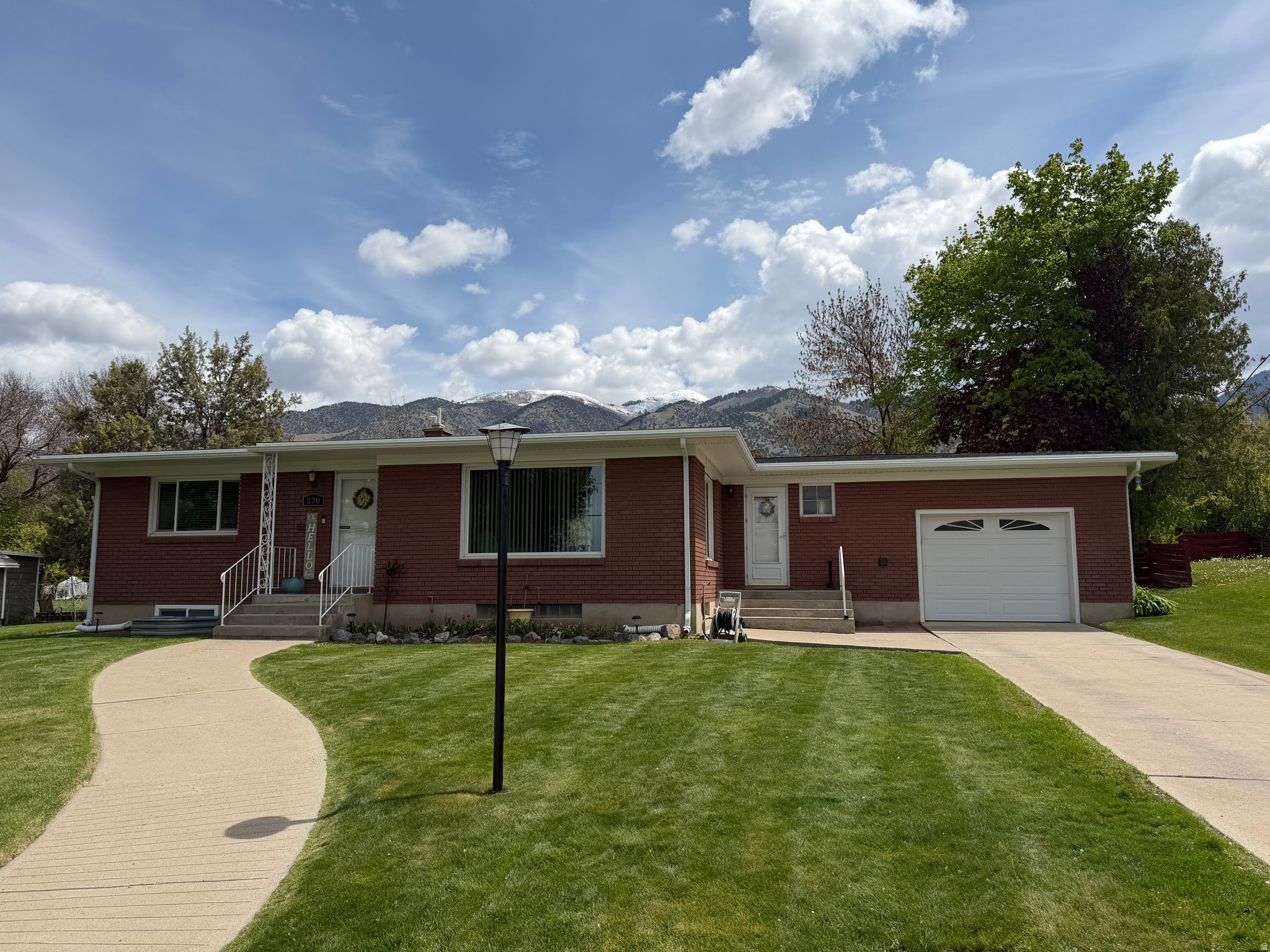 Don't miss out on this welcoming gem! This updated 4bd/2.5ba  2,382 sq. ft solid brick house on a .38 acre lot surrounded by mature trees has a lot to offer. It is conveniently located close to parks, schools, and just minutes from shopping, dining & entertainment. Come on back and enjoy this wonderful large backyard, room for a lot of fun family activities, lot of areas for a huge garden, a large covered East facing patio  where one can enjoy many hot and cool summer days. There are beautiful large apple, plum and other trees, a newly poured 22 ft by 33 ft concrete pad, perfect for some fun basketball or other games. It can also work as a place for extra parking. There is a newer included 10 ft by 20 ft shed where one can store a lot of items. Part of the yard has automatic sprinklers and the east part of the yard has been flood irrigated. One can lease a water share for that through Providence City. The home features 2 family rooms one with large windows, cozy kitchen with LVP floors, stainless steal appliances, built-ins and sliding door out to the great covered patio. The Furnace, A/C and the Water Heater were all replaced 2025 and the microwave was replaced 2026. The larger 1 car garage has a workbench area! Come on over and make your appointment today!