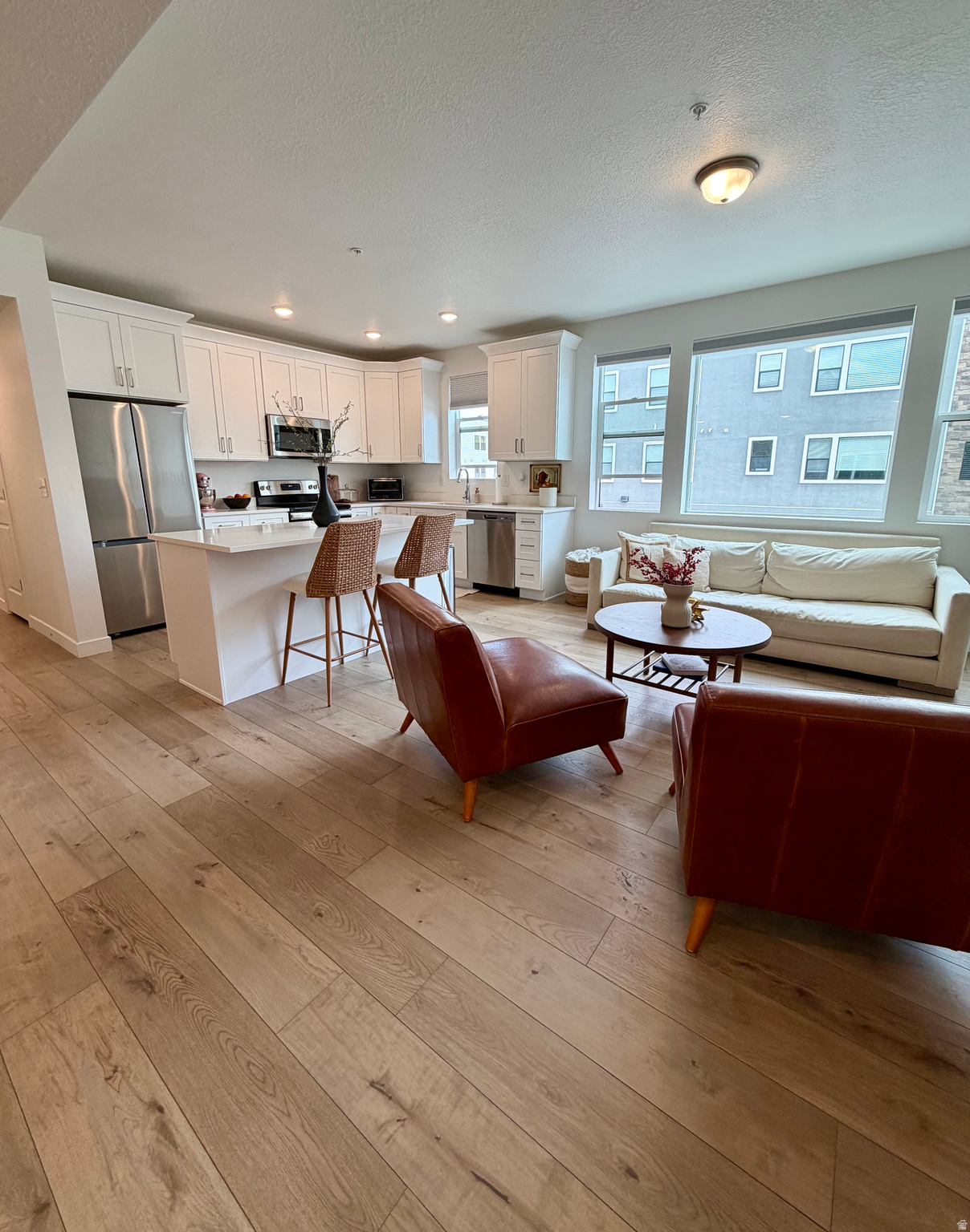 Welcome to this light filled, move in ready 2 bedroom/2 bathroom condo in the heart of Midvale! This like new home offers the perfect blend of modern style and everyday comfort, featuring stunning  flooring throughout the main living areas, modern tile in the bathrooms, and plush carpet in the bedrooms only.   The bright, open kitchen is fantastic with crisp white cabinets, quartz countertops, stainless steel appliances. This home is perfect for hosting friends or enjoying a cozy night in. The open concept layout creates an inviting space that feels both functional and stylish. Located just minutes from freeway access, shopping, dining, and entertainment, you will love the convenience of this central location without sacrificing a peaceful neighborhood feel.   One of the best perks? No active construction in this section of the community. Future amenities, including a park and clubhouse, are being built across the street in Phase 2, so you can look forward to added value while enjoying the quiet today. Whether you are buying your first home, downsizing, or looking for a low maintenance lifestyle, this condo checks all the boxes. Just unpack, settle in, and start enjoying your new home. Agent is related to sellers. Square footage figures are provided as a courtesy estimate only, buyer to verify all.