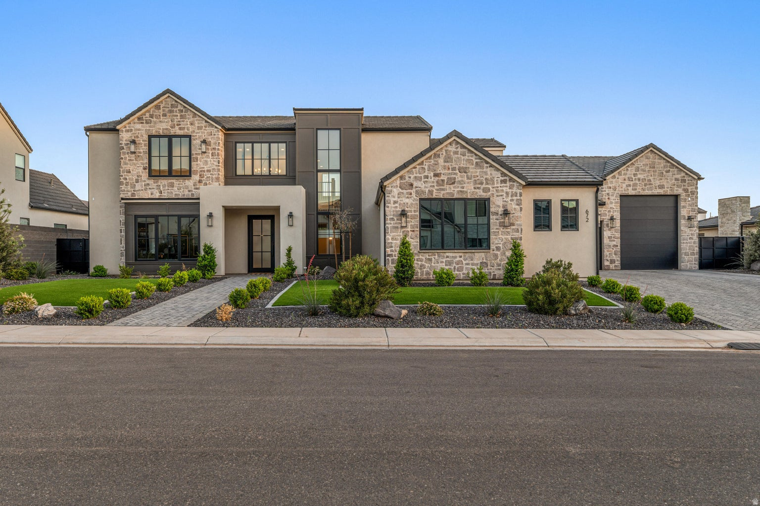 Queensridge Living with Space, Style, and a Backyard That Delivers | Located in Queensridge in Washington Fields, this nearly new custom home offers a clean, well-designed layout with the kind of space and flexibility that make life easier. With 6 bedrooms, 4.5 bathrooms, and just under 4,900 square feet, the home is set up to handle both everyday living and hosting without feeling overdone. The main level includes a spacious primary suite, an additional bedroom, and a dedicated office, while the open living area flows easily into a kitchen built for use--custom cabinetry, an oversized fridge and freezer, a butler's pantry, and plenty of room to gather. Upstairs adds more living space and bedrooms, giving you options for guests, hobbies, or multi-generational living without sacrificing comfort. Out back, the setup speaks for itself. A pool, fire pit, and covered patio create a space that works just as well for a quiet evening as it does for a full house. The oversized 4-car garage with rear access adds the functionality you'd expect at this level, with room for vehicles, storage, and more. Set in a part of Washington Fields that continues to grow, you're close to schools, parks, a new bike park, and everyday conveniences without giving up the neighborhood feel. Homes like this in Queensridge don't come up often--and when they do, they tend to get attention.