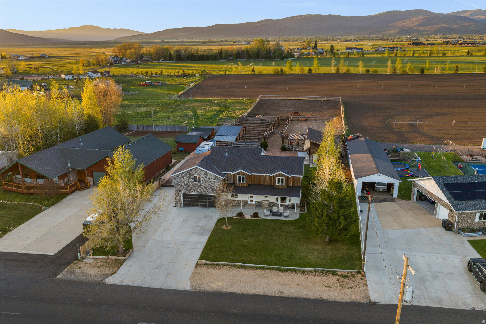 Long Term Seller Financing Available with a minimum of $650,000 down. Rare opportunity to own a luxury equestrian retreat in the picturesque Kamas countryside, just minutes from Park City. Thoughtfully designed, this property offers a highly functional equestrian setup rarely found this close to Park City. Perfectly suited for both horses and humans alike, this peaceful and private estate offers breathtaking sunsets, majestic country and mountain views, and exceptional functionality throughout. Equestrian enthusiasts will appreciate the well-planned setup featuring six horse runs, including two stalls with self-draining stall systems and auto waterers, a pasture area, outdoor working arena, wash bay, beautifully wood-lined tack room, and dedicated hay storage. The back pasture can also be planted, creating the perfect blend of arena space, runs, and lush pasture land. One share of irrigation water is included to help maintain the pasture and landscaping. The property also offers ample space for trailers, RVs, and recreational toys. The exterior has been thoughtfully crafted with matching Martin garage doors, beautiful wood finishes, mature landscaping, rose bushes, peonies, apple trees, and blueberry bushes. The main two-car garage includes a gas heating system, while the separate insulated two-car garage with additional storage offers endless flexibility as a shop, gym, hobby space, or additional garage space. One garage also includes an EV charger, and the property is wired for an outdoor hot tub, creating the perfect place to relax and take in the stunning sunsets after a day with the horses. Additional exterior features include a chicken coop, RV pad, drip irrigation system, inviting front porch, and relaxing back patio overlooking the pasture and surrounding mountain views. The beautifully maintained 5-bedroom, 2.5-bath residence offers approximately 3,420 square feet of luxury country living. The entire interior of the home has been remodeled within the last six years, featuring custom cabinetry, Restoration Hardware vanities, newer carpet, updated appliances, water heater, water softener system, and a dual system heating and air conditioning setup. A high-efficiency wood-burning stove adds warmth and charm to the living space, while the gourmet kitchen is completed with leathered granite countertops. A new Owens Corning roof and exterior were completed approximately 10 years ago, adding both beauty and peace of mind. The main-level primary suite offers convenience and privacy with a beautifully appointed ensuite bathroom. Upstairs, you'll find four additional bedrooms along with a one upstairs bedroom that could also easily be converted into an additional ensuite or guest retreat. A dedicated office features custom cabinetry, a matching desk included with the home, and a built-in safe. Enjoy peaceful evenings watching horses graze from the back patio or take in the sweeping country and mountain views from the inviting front porch. This serene setting truly feels like your own private paradise.