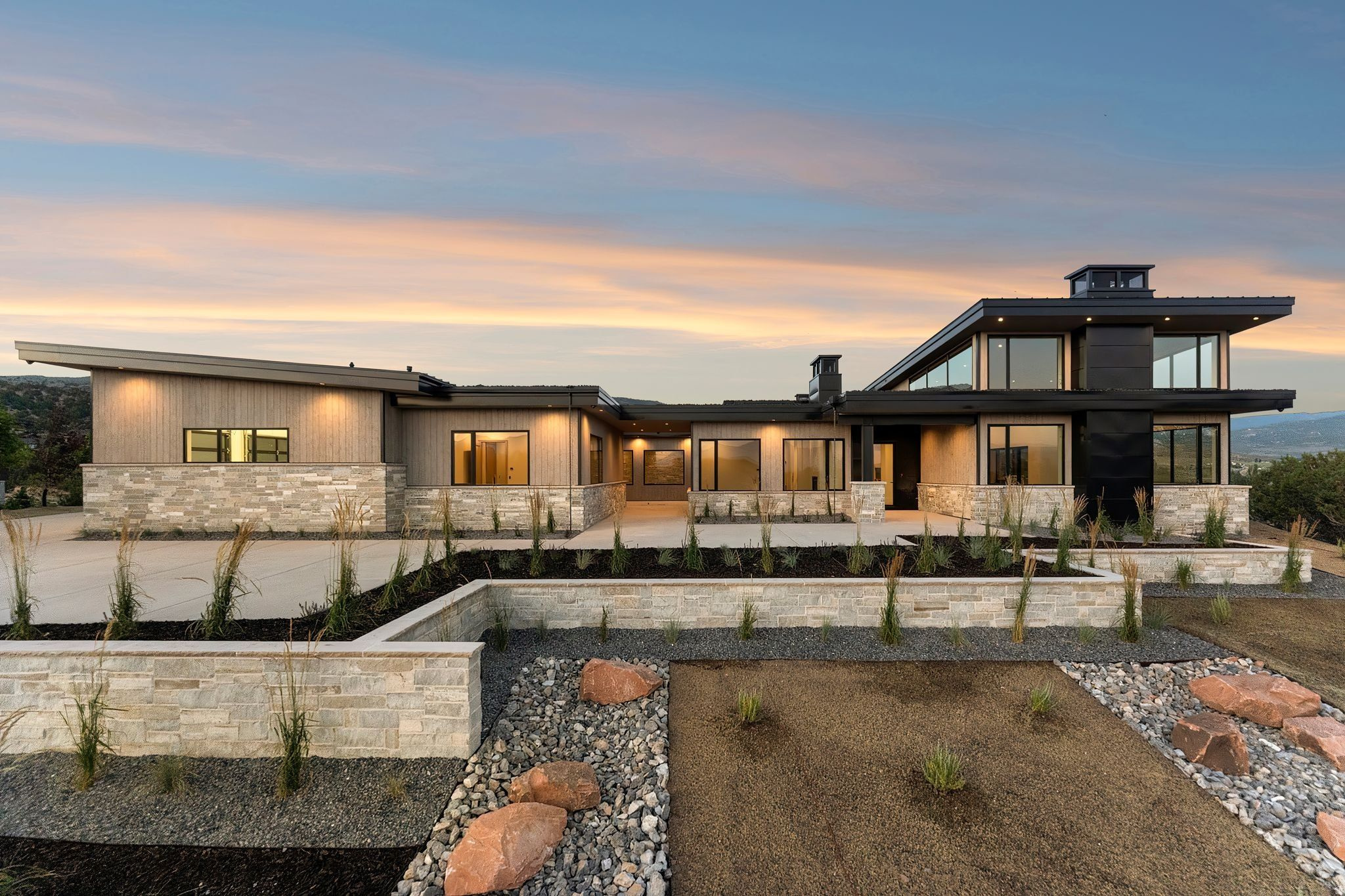 Positioned on a premier homesite in Red Ledges, this exceptional mountain modern residence stands apart for its superior construction quality, thoughtful engineering, and high-end mechanical systems-features rarely found in many newer homes within the community.  Behind the striking architecture and expansive glass lies a home built for long-term performance and comfort, including dual inline tankless water heaters with instant hot-water recirculation, multi-zone HVAC with individual climate control, automated lighting and motorized shades, and a full snowmelt system servicing the driveway, walkways, and courtyard.  Spanning 6,549 square feet, the home was designed to capture abundant natural light and panoramic mountain views through walls of glass and soaring ceilings. The open-concept great room is anchored by a dramatic floor-to-ceiling stone fireplace and flows seamlessly to expansive covered terraces positioned to take in breathtaking views of Mt. Timpanogos and the surrounding Wasatch landscape.  At the center of the home, the chef's kitchen features a stunning stone waterfall island, custom cabinetry, and premium Thermador appliances including a 60-inch dual-fuel range, dual dishwashers, and full refrigerator and freezer columns. A fully equipped butler's pantry with additional refrigeration, sink, pellet ice maker, and beverage drawers makes entertaining effortless.  The home offers four luxurious bedroom suites, each with private en-suite baths and heated tile floors. The primary suite serves as a true retreat, featuring a spa-inspired bathroom with steam shower, while the adjacent wellness space includes a full gym, dry sauna, and cold plunge.  Home comes fully furnished with designer Restoration Hardware furniture and decor, turn-key, ready to enjoy immediately.  Additional highlights include a private home theater with 4K projection, whole-home Sonos audio system, three laundry stations, and an impressive four-car garage with high-lift doors, built-in heaters, custom cabinetry, floor drains, and integrated pressure-wash system.  With its rare combination of architectural design, premium construction, and luxury lifestyle amenities, this residence represents one of the most thoughtfully built homes currently available in Red Ledges.