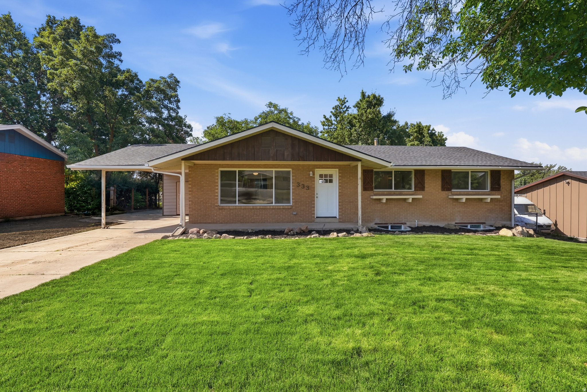 Stunning 5-bed, 2-bath brick rambler in the heart of North Ogden! Offering 2,380 sq ft of beautifully updated living space on a 0.23-acre lot, this home blends classic charm with modern convenience. The bright, open-concept main level features expansive picture windows, light-wood laminate flooring, and generously sized bedrooms. Step through sliding glass doors into an incredible enclosed sunroom-your perfect year-round oasis for entertaining or relaxing.  The 100% finished walk-out basement doubles your space, boasting a large family room, additional bedrooms, and a stunning updated bathroom with a sleek curved-glass shower and white subway tile. Enjoy seamless indoor-outdoor living with direct backyard access!  Exterior perks include a low-maintenance brick facade, covered carport, and RV parking.  Square footage figures are provided as a courtesy estimate only and were obtained from county records.  Buyer is advised to obtain an independent measurement.