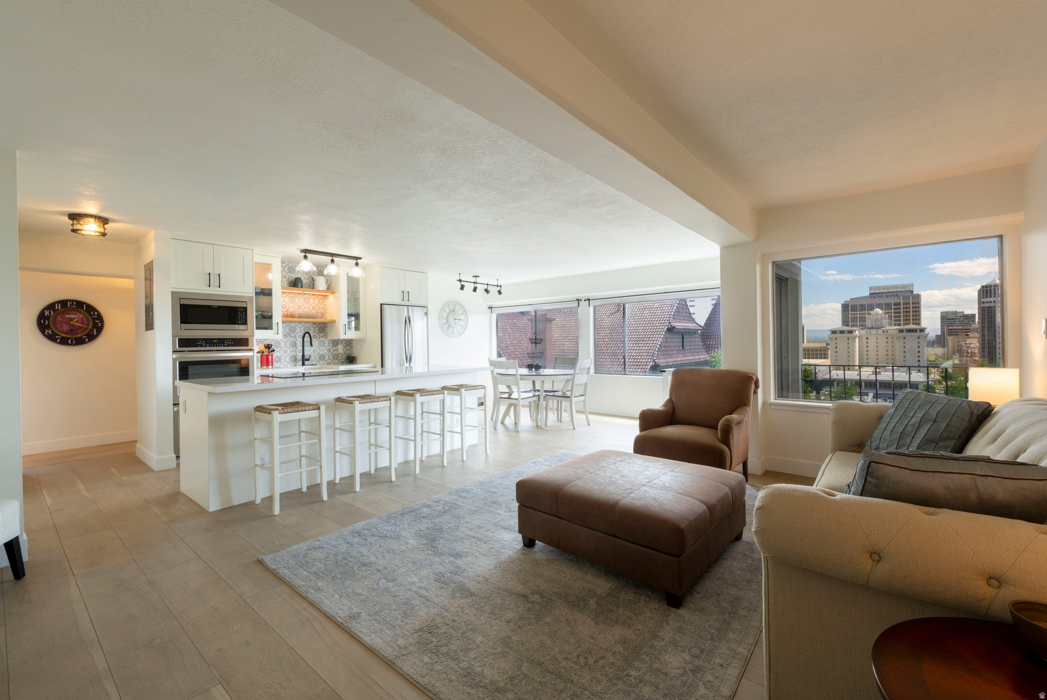 Perched high above the city in the Panorama Condominiums on Capitol Hill, this stunning residence captures sweeping, unobstructed views of downtown Salt Lake City, the valley, and the surrounding Wasatch mountains.  The classic mid-century building has been thoughtfully refreshed with major updates, including a new roof, exterior paint and stucco, HVAC, elevator, and a resurfaced pool and deck area-offering the charm of a vintage building with the peace of mind of modern improvements. Inside the unit, an expansive wall of windows floods the home with natural light and perfectly frames the city vistas, creating an elevated urban retreat. The spacious, open-concept layout is ideal for both everyday living and entertaining. A beautifully updated eat-in kitchen features custom cabinetry, quartzite countertops, a large center island, and great flow into the living and dining areas. Step outside to your private, covered balcony to savor coffee at sunrise, unwind with evening city lights, or enjoy outdoor living year-round. The primary bedroom offers a peaceful escape with generous dimensions, custom closets, and built-in cabinetry for effortless organization. A second bedroom offers flexible use as a guest room, home office, or creative studio. The well-appointed bath includes a convenient in-unit washer/dryer combo, maximizing functionality and comfort. Residents of Panorama enjoy secure, controlled access, garage parking, additional storage, and resort-style amenities including a private pool, expansive sun deck, and beautifully maintained grounds. This particular unit is prized for having some of the very best views in the entire building. All of this is just steps from the heart of downtown-City Creek Center, Temple Square, top-rated dining, boutiques, sporting events, performing arts, and cultural attractions are right at your doorstep. With its unbeatable location, dramatic views, and turnkey updates, this home defines effortless city living at its finest.
