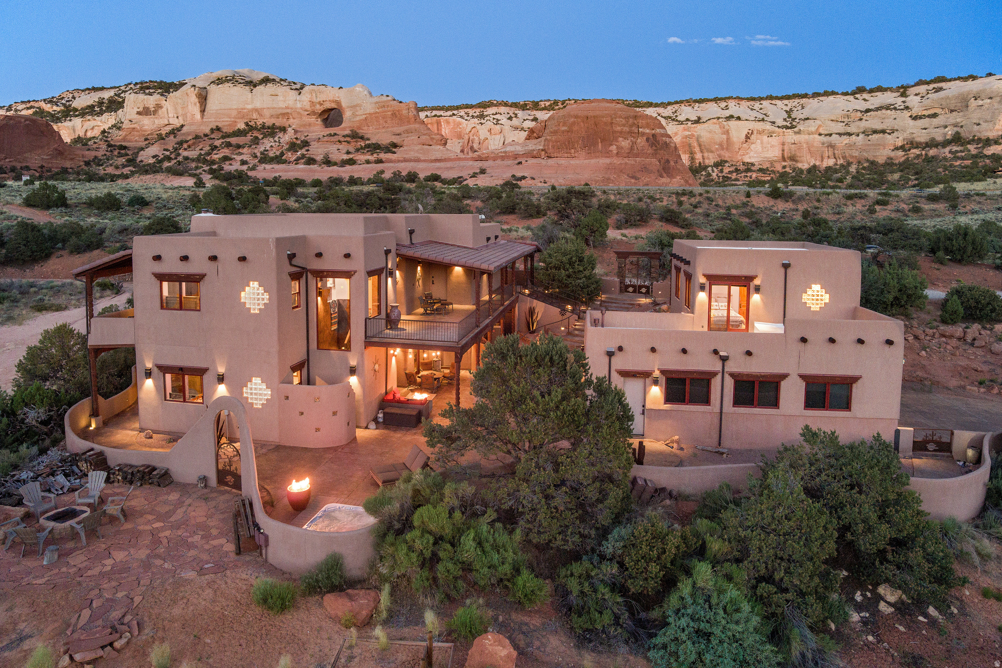ESCAPE TO YOUR DESERT RESORT- Here is your destination estate for adventure in Southeastern Utah. A convergence of peace, artistic expression, custom detail, luxury, rugged beauty, and fun...in one incredible package. Bring your bags, bring your toys, stop at the grocery- then land  once you are here, you won't want to leave. Over 5 acres of desert landscape adjoining additional deeded open land allows for a setting of absolute privacy and intimacy with the surrounding vistas. With seven patios covering over 4,300 square feet, the outdoor living is as incredible as the southwestern interior. Celebrating the local surroundings with custom paint finish on the American Clay walls, travertine tile that flows in patterns equal to the neighboring arroyos, celestial hard wood vigas that broaden the awe-inspiring dining room above the wall to ceiling windows, stacked stone, and kiva fireplaces. Thermador appliances, including a built-in espresso machine, accommodate this exceptional kitchen with alder cabinets offering plentiful storage, living edge granite counter tops, as well as the custom hammered copper features- island inlays, dual bay sink, and vent hood. The main bedroom suite has access to the outdoor kitchen patio with fireplace and additional access to the surrounding covered patios with massive fire features. Two additional guest en-suites, an extra bedroom, music room, game room, theater room and lower-level kitchenette/wet bar with hammered nickel sink and ice maker, all allow for spacious, and entertainment filled gatherings. On the other side of the stamped concrete and beautifully lit courtyard is the guest casita with one-bedroom, full bathroom, kitchenette, and private covered patio, as well as a view balcony. Soak your bones in the sunken hot tub, adjacent to more fire features, the flagstone fire pit, horseshoe pit, and surrounding area to set up your frisbee golf course. This desert escape the base furnishings. The attached oversized garage has over 1,100 square feet of space for your toys. Ready to escape? Square footage figures are provided as a courtesy estimate only and were obtained from images. Buyer is advised to obtain an independent measurement.
