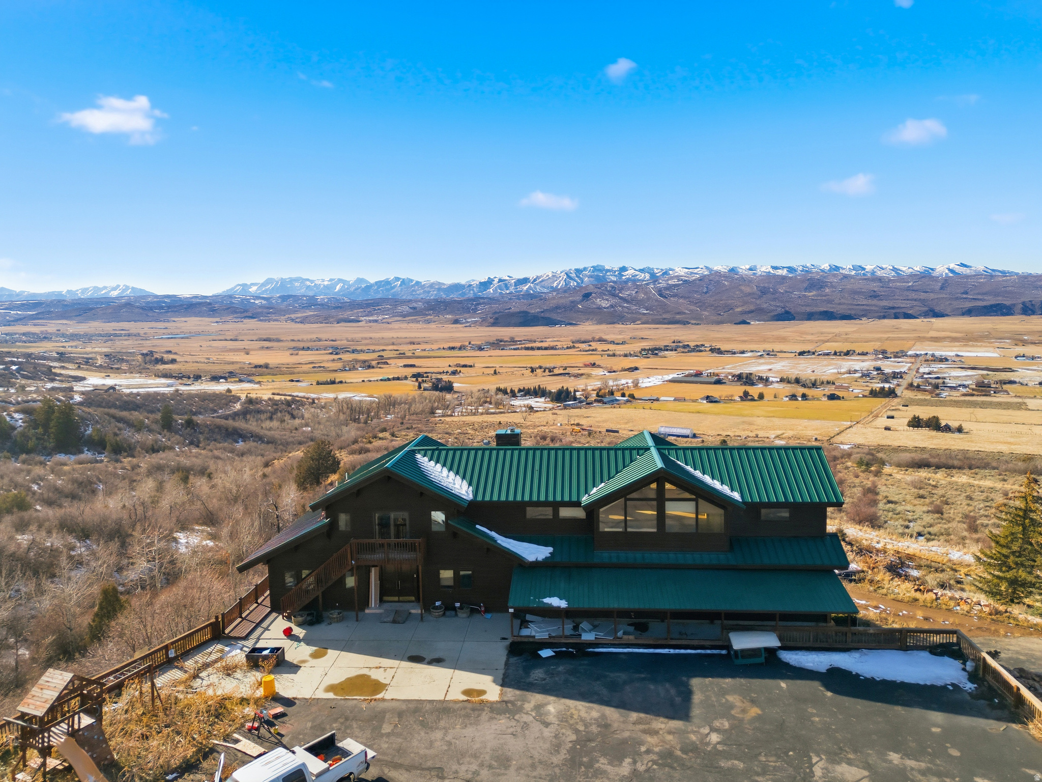 Set across 316 acres in Summit County's Elk Hills, 3090 N Rocky Road offers a rare opportunity to own a private mountain estate with unobstructed views, overlooking the Kamas Valley and stretching across the Wasatch Mountain Range, including Deer Valley and Mount Timpanogos. Elevated above the valley floor and bordered by thousands of acres of National Forest, the property delivers a sought-after combination of dramatic scenery, privacy, and scale in one of Utah's most desirable rural mountain settings. The land features rolling terrain, natural water elements, including a stream, and abundant wildlife, creating an ideal environment for a legacy family compound, recreational ranch, or conservation-minded ownership. Sunrises over the valley and sunsets against the Wasatch peaks provide a constantly changing backdrop, with panoramic sightlines that rival any setting.  Existing improvements support immediate use while allowing flexibility for future development. A large barn with finished interior spaces includes entertainment and recreational areas, additional bedrooms and bathrooms, and flexible gathering spaces. A secondary garage structure provides RV storage and additional utility. Significant infrastructure investments include a private gated entrance with paved access, a solar system with battery backup capable of off-grid operation, included water rights, and Greenbelt tax status. All this only 30 minutes from Deer Valley for skiing and Park City's Historic Main Street for shopping and fine dining. Less than one hour from Salt Lake City International Airport and the private Heber Valley Airport. Previously approved for elk farming, the property includes extensive high fencing suitable for wildlife or agricultural use. The acreage, viewshed, and location may also support future subdivision or development potential, subject to Summit County approvals.  Whether envisioned as a private mountain retreat, working ranch, or long-term land investment, this property represents a rare opportunity to secure a premier vantage point overlooking the Kamas Valley and the iconic Wasatch skyline.