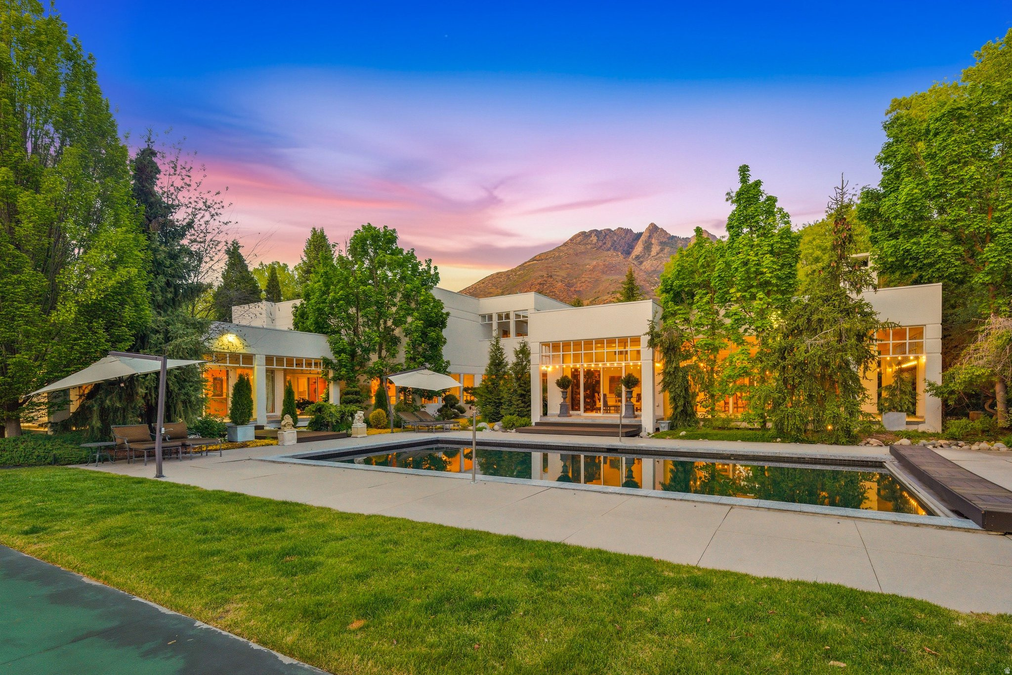 Tucked away on a private lane in one of Salt Lake's most desirable areas, this remarkable estate offers nearly 7,000 square feet of beautifully designed living space surrounded by mature landscaping, flowing streams, and exceptional privacy. Accessed through three private gates, the property creates a rare sense of seclusion while still being conveniently located near shopping, dining, schools, hiking trails, and canyon recreation. Thoughtfully designed to bring the outdoors in, the home is filled with natural light from expansive windows and skylights that showcase the stunning surroundings from nearly every room. Offering 4 spacious bedrooms and generous gathering spaces throughout, the home combines comfort, functionality, and timeless character. The expansive kitchen is designed for both entertaining and everyday living with abundant space, quality finishes, and seamless flow into the main living areas. The primary suite serves as a peaceful retreat, perfectly positioned to take in the tranquil setting and surrounding greenery. Step outside and experience a true backyard sanctuary featuring a pool, tennis court, mature trees, open lawn areas, and the soothing sounds of the stream running through the property. Whether hosting gatherings or enjoying quiet evenings at home, the grounds offer an extraordinary setting rarely found in Salt Lake. A rare opportunity to own an exceptionally private property with resort-style amenities, beautiful natural surroundings, and an unbeatable location.   Square footage figures are provided as a courtesy estimate only and were obtained from county records.  Buyer is advised to obtain an independent measurement.