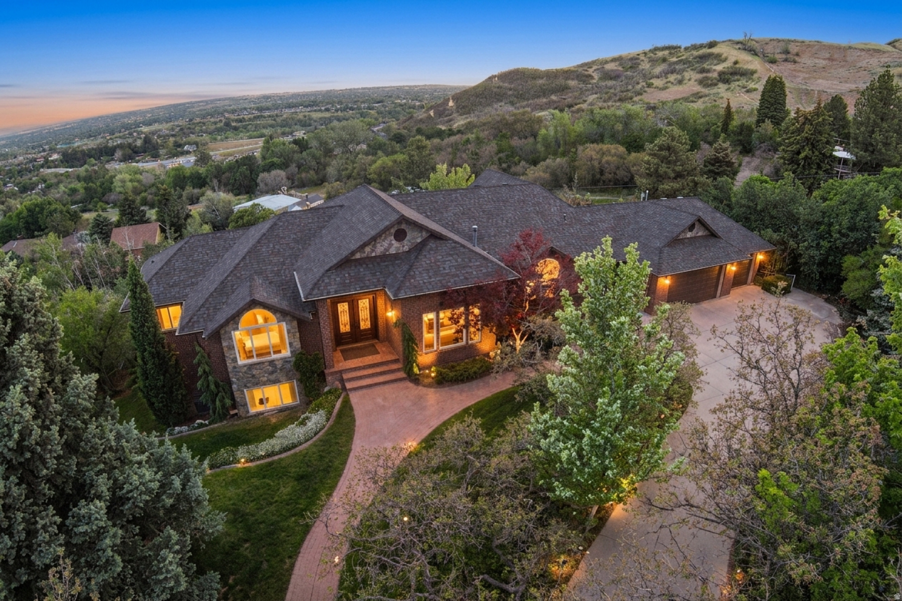 Welcome to Twin Peaks Cove - private, mature landscaping with unobstructed sunset and valley views. Easy access to the Bonneville Shoreline Trail for hiking and mountain biking and only 20 minutes to Snowbasin. Enjoy a custom built-in office with rolling ladder, a large downstairs family room with projector and screen, plus neighborhood pool and clubhouse. Updated systems: front sprinkler 2022, back 2026; one furnace and one AC 2026; roof 2016; two water heaters 2025; kitchen remodeled 2010. Chef's kitchen: Viking cooktop, Wolf oven, SubZero fridge, ice maker, two sinks and two dishwashers; Kinetico water filtration, wholehouse generator and EV charging hookups (charger excluded). Seller includes riding snow blower. Back deck, fire pit and a large yard with sledding hill - "milliondollar" views to live above the inversion. Ring doorbell included; craftroom furniture available. Recently appraised at $1,715,000. Seller to provide $50,000 allowance to buyers for carpet and paint.