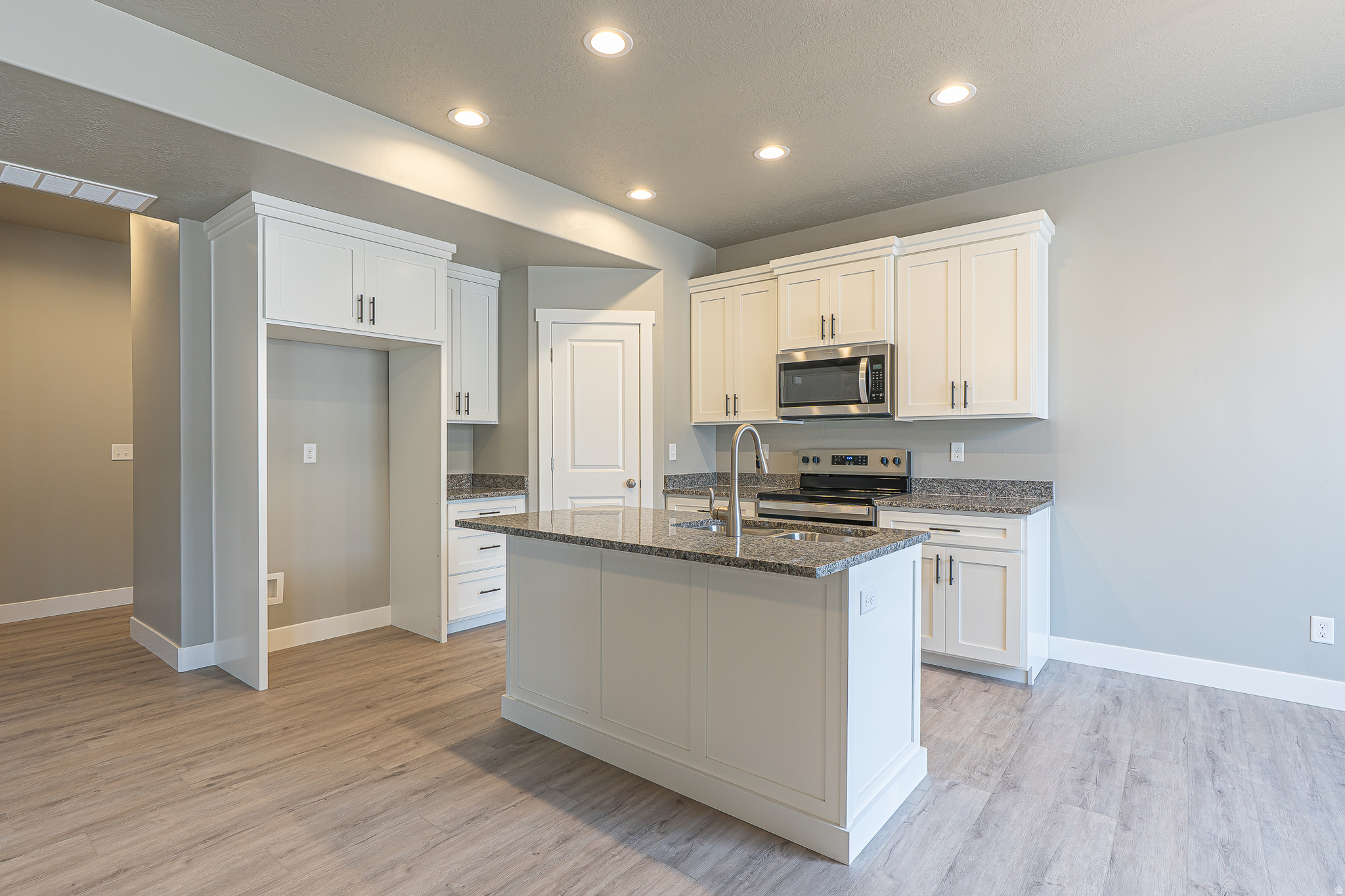 Beautiful move-in ready townhome featuring stylish gray cabinetry, granite countertops, two-tone paint, and a spacious primary suite with tray ceiling. Clean lines, warm finishes, and thoughtful details create a welcoming space that feels more like a home than a typical townhome.