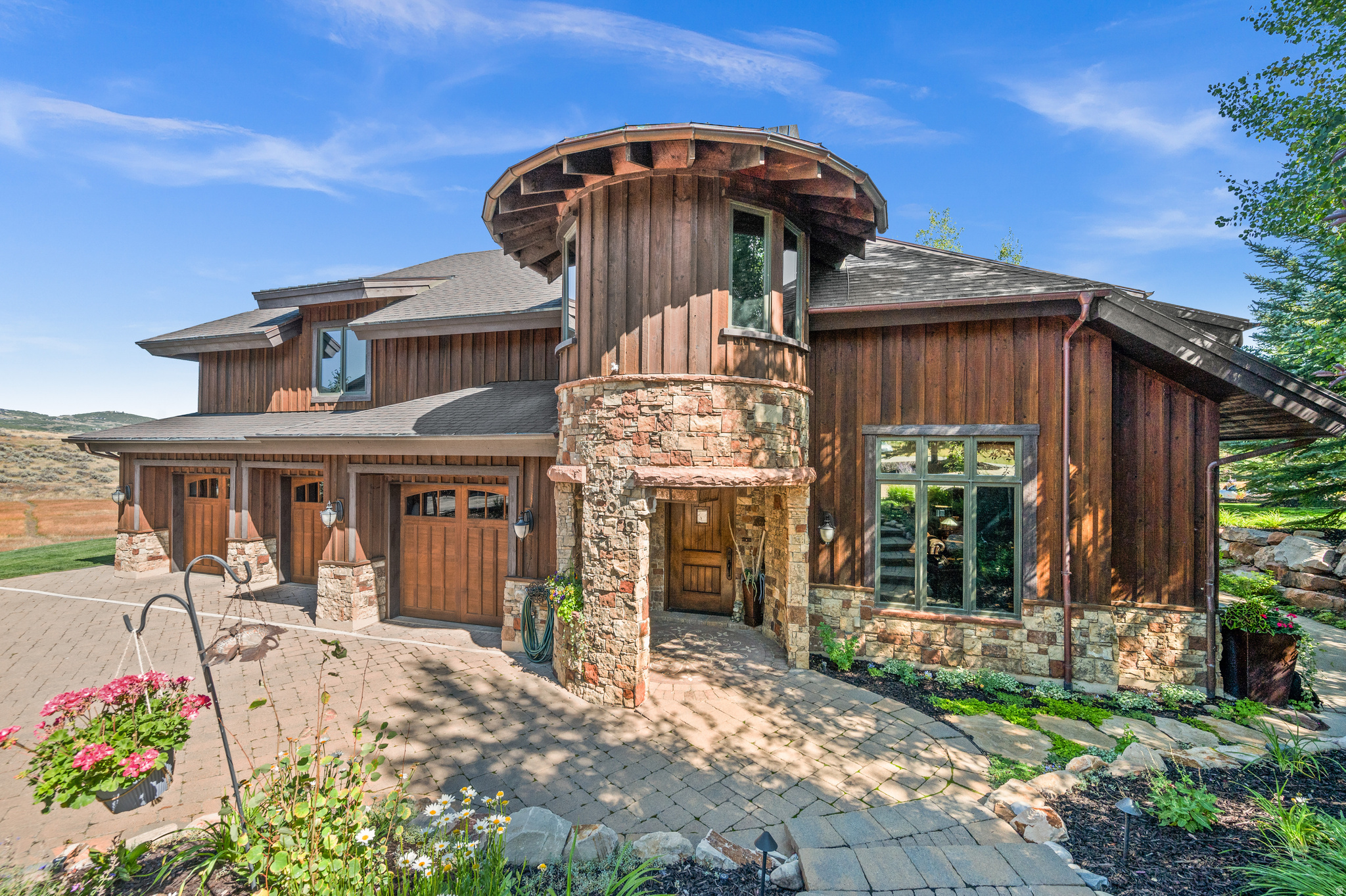 Tucked away in an exclusive enclave, backing directly to The Preserve, this extraordinary mountain retreat offers rare privacy, breathtaking views, and seamless indoor/outdoor living. Designed for both elegance and functionality, this south-facing gem captures stunning natural light and panoramic vistas of local wildlife, a daily backdrop for serene mountain living. The thoughtful design features 4 spacious ensuite bedrooms, a fully built-in executive office, and a third-story loft with generous storage. Soaring vaulted ceilings, three operable skylights, and a whole-house fan enhance the home's airy feel and provide natural climate control. The gourmet kitchen is a chef's dream, complete with premium appliances, an adjacent outdoor dining area, and a custom wine bar featuring a sink, 80-bottle wine fridge, and two refrigerated beverage drawers. Additional highlights include a cozy kitchen/coffee nook with its own fridge, sink, and microwave, a convenient laundry chute with W/D hookups on the bedroom level, and four floor-to-ceiling stone fireplaces throughout the home. Outdoors, your private alpine oasis awaits. Heated driveways and walkways guide you to a secluded spa and fire pit overlooking the protected lands of The Preserve. Entertain in true mountain style with an authentic brick/wood-fired pizza oven, full outdoor kitchen (AlFresco grill fridge and warming drawer, sink, and ice maker), covered, heated dining area, and multiple heated patios, perfect for gatherings under the stars. Surrounded by mature landscaping and framed by sweeping views, this home offers a peaceful, private sanctuary ideal for quiet retreats and lively summer celebrations. In the winter, enjoy the ease of a heated garage and snow-melt driveway.