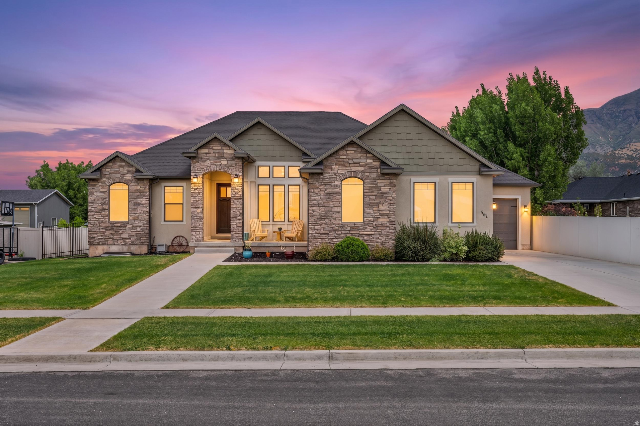 Beautifully designed rambler with a fully finished basement, 3 car garage, RV parking, and the kind of layout that gives you flexibility, function, and space to spread out. From the moment you arrive, the custom front door, welcoming front porch, and impressive entry foyer set the tone for this well cared for home. Inside, you will love the open concept kitchen and living space featuring white cabinetry, black granite countertops, soft close cabinets, under cabinet lighting, double ovens, built in microwave, and a 36" cooktop with gas hookup option and 5 burner setup. The spacious living room includes custom built ins surrounding the gas fireplace and tile flooring that gives the warm look of hardwood with easy maintenance.  The primary suite offers a relaxing retreat with a soaking tub, separate shower, and walk in closet. Main floor also includes a half bath and oversized laundry room with built ins for additional storage and organization. The 3 car garage includes both hot and cold water hookups and extra room for projects, storage, or toys.  Downstairs features a large family room, office/flex room, kitchenette with fridge and microwave, and multiple bedroom setups including a Jack and Jill layout with separate vanities, shared tub/toilet area, and walk in closets. Another bedroom setup offers private bath access with large closet space, making the basement ideal for guests, multi generational living, or additional living flexibility. Tons of storage throughout the home, including under patio storage and internet access in the storage room.  Outside, enjoy the fully fenced yard, covered patio, sprinkler system in both front and back, oversized concrete parking area, and dedicated RV parking. This home combines comfort, thoughtful upgrades, and everyday practicality all in one beautiful property.