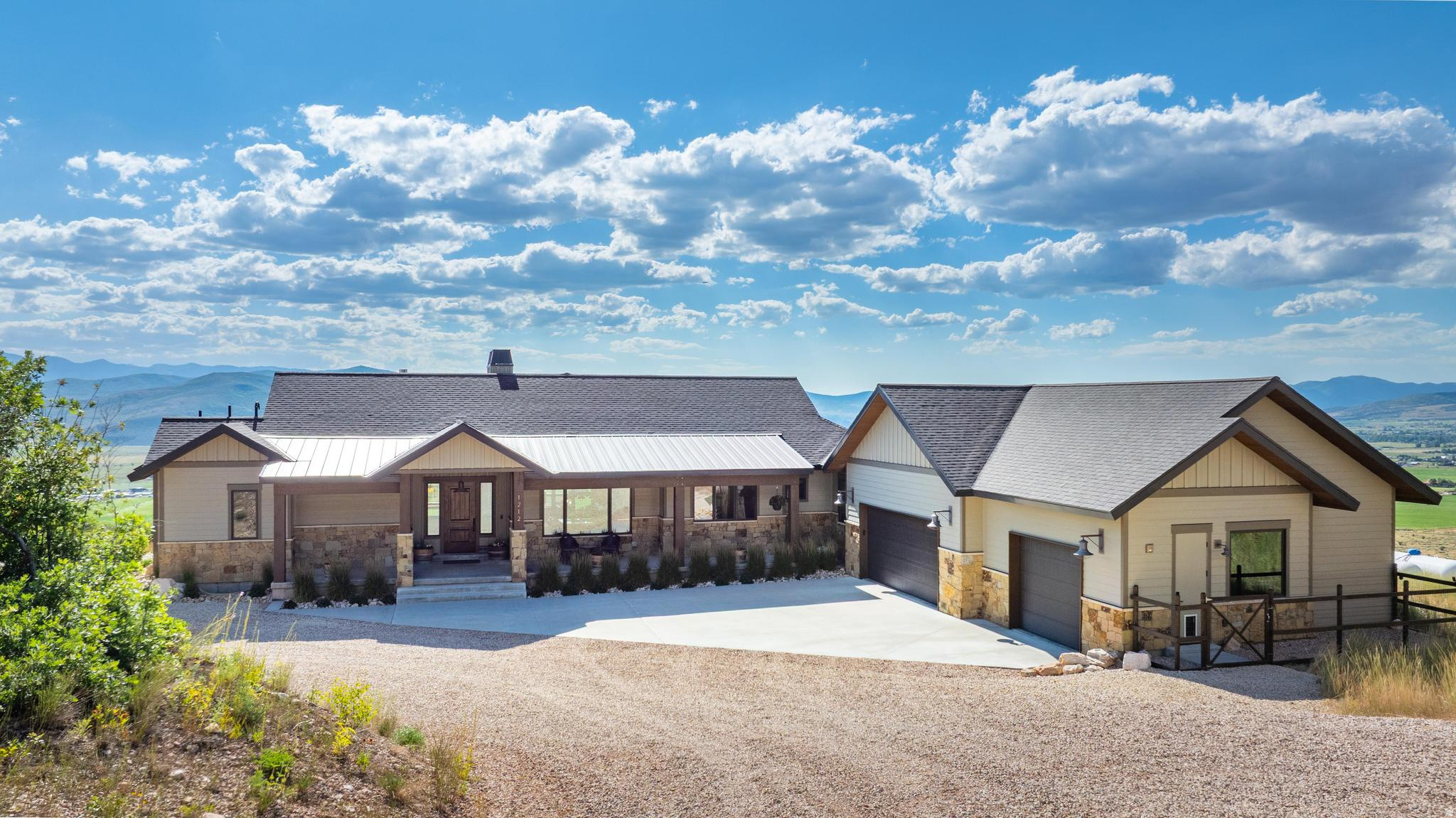 When your house is more than a home, it's a simpler way of living, surrounded by nature and unmatched views. Welcome to your own private retreat, in scenic Kamas. Enjoy the perks of plenty of land, complemented by easy access to the world-renowned skiing, shopping, and dining of Park City. With direct access to the Uinta's Wasatch Cache National Forest, ride your horses or ATV's right from the garage up into the mountains. It's also just 45 miles from Salt Lake City. An open-concept floor plan creates the ideal flow for hosting or relaxing at home. Within the large kitchen, you'll find an island, plenty of cabinet and counter space, and double ovens with a gas cooktop. Making all your favorite meals will be a breeze in this chef's dream space, especially with a butlers pantry for additional storage. The primary suite features a private covered patio and a gas fireplace, ensuring the space remains comfortable year round. Other appealing upgrades include a walk-in closet with laundry hook ups and an ensuite with a separate soaking tub and shower. The lower level of the home is a full ADU unit with a full kitchen, laundry, and a bright walkout basement entrance. Head outdoors to find another covered patio, serving as the ideal spot for watching the sunset or relaxing with your morning coffee. High-end upgrades include dog wash in one bay of the oversized garage, an additional 1976 square foot shop, a backup generator and custom lighting throughout the home. With too many features to list you need to see this one in person. Around every corner, you'll enjoy blue-sky views for miles, making this the perfect place to call home. Additional land available.