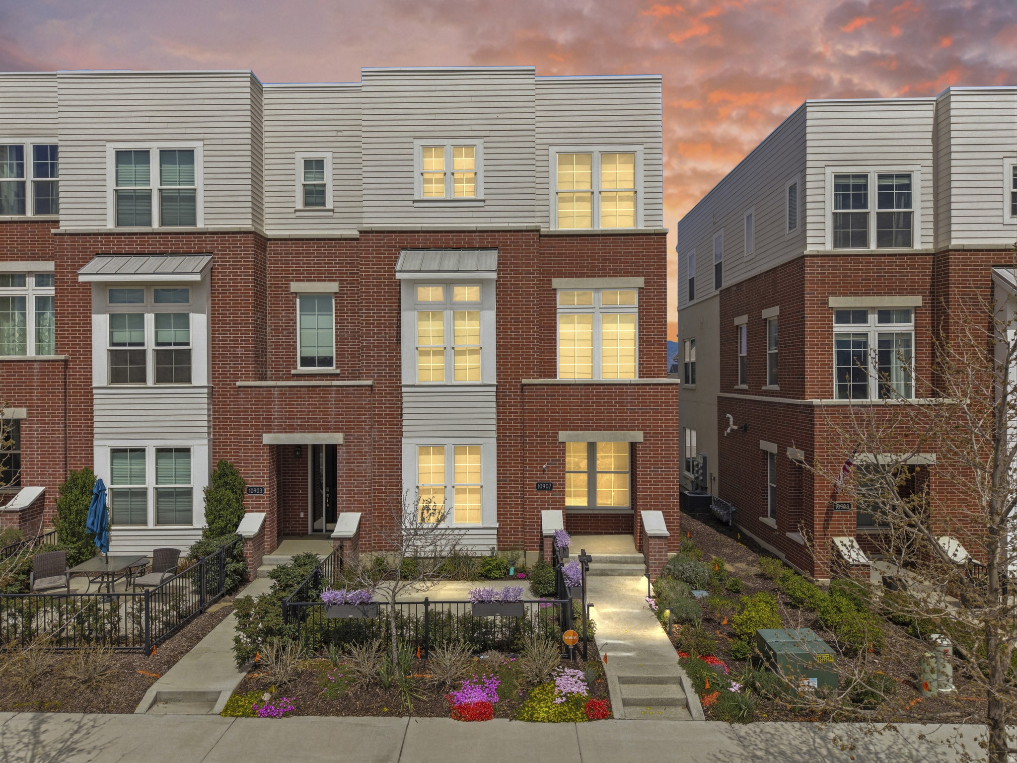 Welcome to this exceptional end-unit Brownstone Series townhome in the heart of Daybreak's highly sought-after Heights Park Village. Perfectly positioned just one block from the Salt Lake Bees Ballpark and Daybreak's exciting new entertainment district, this home offers direct stadium views and an unbeatable walkable lifestyle.  From the striking brick exterior and covered front porch to the fenced front patio, this home exudes timeless Brownstone charm with sophisticated modern finishes throughout. Inside, oversized windows flood the open-concept main level with natural light, creating an inviting space for both everyday living and entertaining.  The stunning chef's kitchen is the centerpiece of the home, featuring dual islands, quartz countertops, a gorgeous Italian Carrara marble backsplash, abundant cabinetry, and a premium suite of Frigidaire Professional and Bosch appliances. Designer lighting and thoughtful finishes elevate every detail.  Upstairs, the luxurious primary suite offers a peaceful retreat with a spa-inspired ensuite featuring a soaking tub, separate shower, double vanity, and elegant designer tile. With an impressive five walk-in closets throughout the home, storage will never be a concern.  The versatile floor plan includes a private ground-level guest suite with its own full bathroom, perfect for visitors, multigenerational living, or a home office. Additional highlights include brand-new Shaw carpet (2025), Mannington laminate flooring, quartz countertops throughout, dual-zone HVAC, a Noritz tankless water heater, and a beautifully finished epoxy garage floor.  Technology enthusiasts will appreciate the extensive smart home features, including a Vivint security system, smart lighting, Google Nest Hub, and dual Nest thermostats.  Located just minutes from Downtown Daybreak, SoDa Row, Oquirrh Lake, TRAX, miles of walking and biking trails, community pools, fitness facilities, parks, shopping, dining, and entertainment, this home offers access to everything that makes Daybreak one of Utah's premier master-planned communities.  Opportunities to own a Brownstone of this caliber in such a premier location are rare. Schedule your private tour today and experience the perfect blend of luxury, convenience, and the vibrant Daybreak lifestyle.