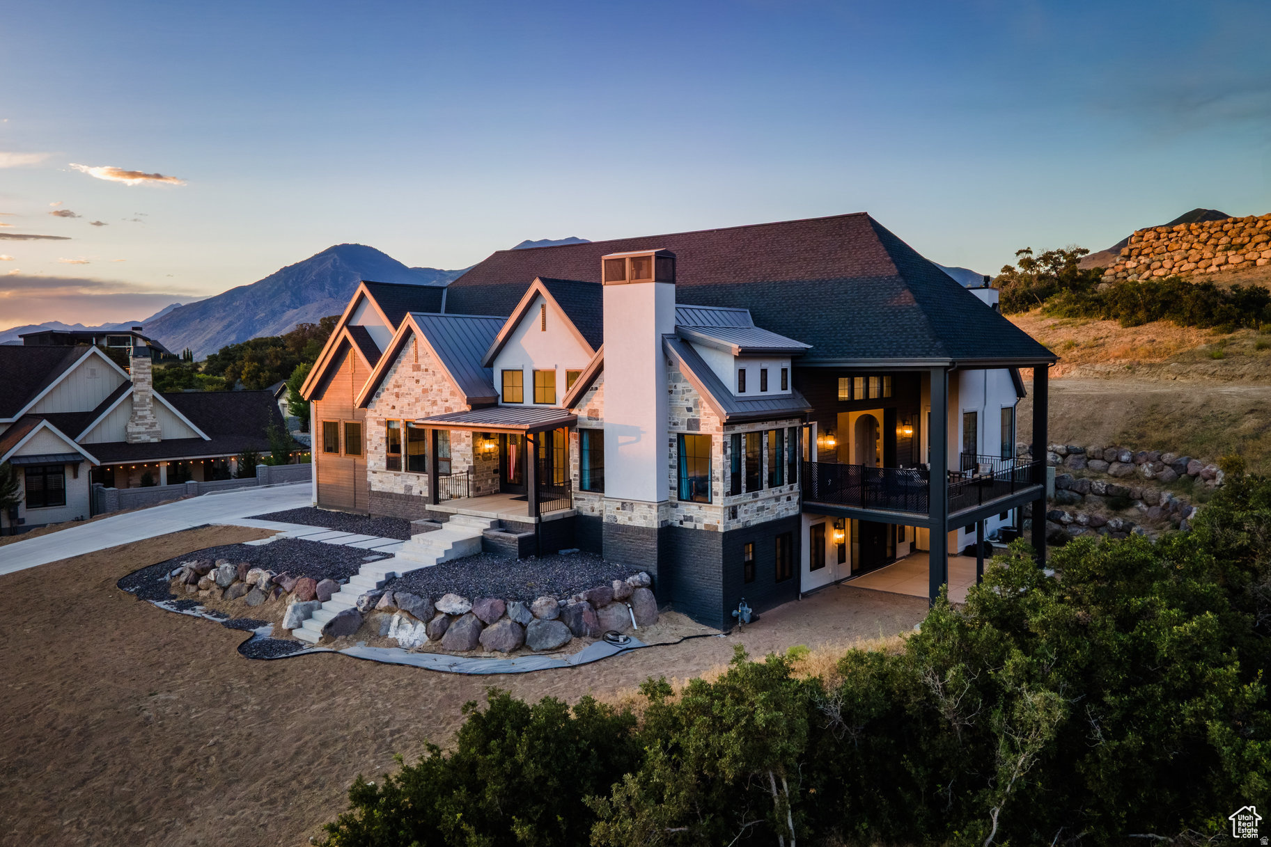 Now Offered with a $100,000 Price Improvement - Elevated Luxury in Twin Hollow!  Completed in 2023, this exceptional 9,210 sq ft estate in Mapleton's prestigious Twin Hollow community delivers a refined living experience defined by scale, craftsmanship, and thoughtful design. This new price improvement offers the flexibility to craft a custom landscape that complements the home's elevated design. From the moment you enter, the home showcases expansive open living spaces, soaring ceilings, and seamless indoor-outdoor integration through disappearing multi-slide glass doors. The oversized deck frames unobstructed mountain views, creating a private, elevated backdrop for both quiet evenings and sophisticated entertaining.  The chef's kitchen is a true centerpiece-featuring dual oversized islands, a fully equipped butler's pantry, and premium Italian Bertazzoni appliances, including double ovens and a six-burner cooktop with integrated grill. Designed for both performance and presentation, this space caters effortlessly to gatherings of any scale.  The main-level primary suite offers a private sanctuary, complete with vaulted ceilings, heated floors, and a spa-inspired bath paired with a generous walk-in closet. The lower level is dedicated to lifestyle and leisure, featuring a state-of-the-art theater with a 192-inch screen, an elegant wet bar, expansive entertaining areas, and a glass-enclosed fitness studio.  Additional amenities include:  Oversized 5-car garage  Three laundry rooms for ultimate convenience  Advanced comfort systems with multiple furnaces, A/C units, and humidifiers  High-performance argon-filled windows and doors  A private-entry salon adds versatility-ideal as a guest suite, executive office, or bespoke studio. This is more than a home-it is a statement of lifestyle, offering luxury, privacy, and modern sophistication in one of Mapleton's most coveted neighborhoods.
