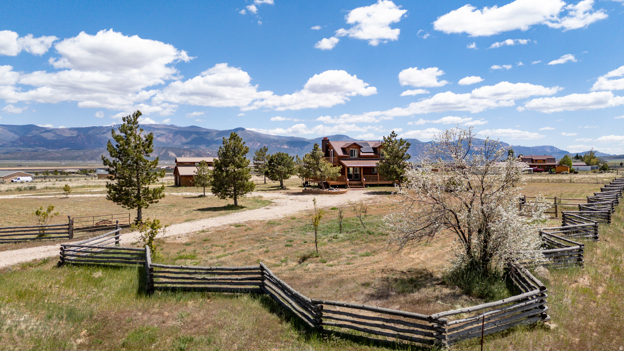 Create the homestead lifestyle you've been dreaming of on this beautiful 5-acre ranch property in Cedar City. Gorgeous log home with over 2,000 square feet, 4 bedrooms, 3 bathrooms. The 40' x 36' 4-stall barn includes 2 roll-up doors for 2 car garage parking, a workshop, 220V power, saddle racks, heated water troughs, and 2 additional flex rooms above with wall mounted A/C. Warm wood finishes carry throughout the home where you'll find tongue and groove beamed ceilings that create a stylish contrast to the modern kitchen complete with farmhouse sink and custom cabinetry features you'll love! ALL appliances stay. Spacious wrap around deck with picturesque views. Walk-out basement. The fully fenced acreage offers 3 separate areas, ideal for animals. Private well with 3 acre-feet of water. Recent updates include new windows, roof, well pump, deck and updated kitchen. Enjoy low utility payments with solar panels and a woodburning fireplace or stove on each level. Come, kick back, relax and enjoy!