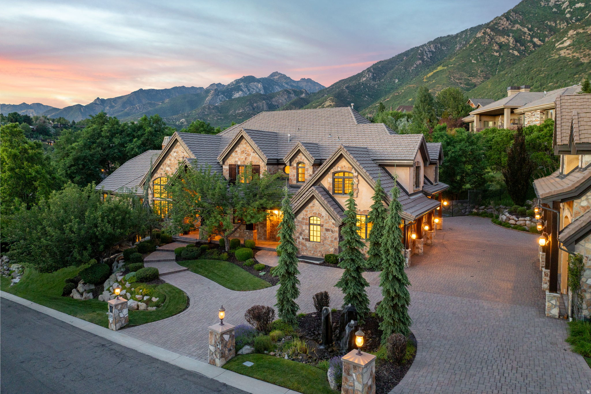 Experience an extraordinary level of craftsmanship, space, and amenities in this remarkable estate located within the prestigious 24-hour guard-gated Pepperwood community. Thoughtfully designed with soaring ceilings on every level, oversized windows that fill the home with natural light, and breathtaking mountain views, this residence offers an exceptional blend of elegance, comfort, and functionality. The spacious main-level primary suite serves as a private retreat with a spa-inspired bathroom and oversized walk-in closet, while most additional bedrooms feature their own en-suite bathrooms for added comfort and privacy. The gourmet kitchen is designed to be the heart of the home, seamlessly connecting to expansive gathering spaces perfect for entertaining. The walkout lower level is unlike anything else, featuring a second full kitchen, theater room complete with screen and recliners, golf simulator, craft room, commercial-style gym, and a spectacular indoor basketball court with its own observation room and wet bar. A secure underground walkway connects the home to the detached garage, bringing the total to seven heated garage bays-ideal for collectors, recreational vehicles, or additional storage. Above the detached garage is a fully finished apartment featuring a bedroom, en-suite bathroom, and additional half bath, making it perfect for guests, extended family, or a private office. The backyard is designed for year-round enjoyment with a swimming pool and slide, in-ground trampoline, putting green, playhouse, built-in BBQ, and a fully equipped outdoor kitchen. The expansive covered patio provides welcome afternoon shade, creating the perfect setting for outdoor dining and entertaining. Pepperwood offers an unmatched lifestyle with resort-style amenities including a lifeguarded pool and hot tub, competitive swim team, tennis, pickleball and volleyball courts, a newly renovated playground, and miles of scenic walking and biking trails. Ideally located just minutes from world-class skiing in Little Cottonwood Canyon, top-rated schools, hiking, shopping, dining, and everyday conveniences, this exceptional property offers a rare opportunity to enjoy one of Draper's most sought-after communities.   Square footage figures are provided as a courtesy estimate only and were obtained from county records.  Buyer is advised to obtain an independent measurement.