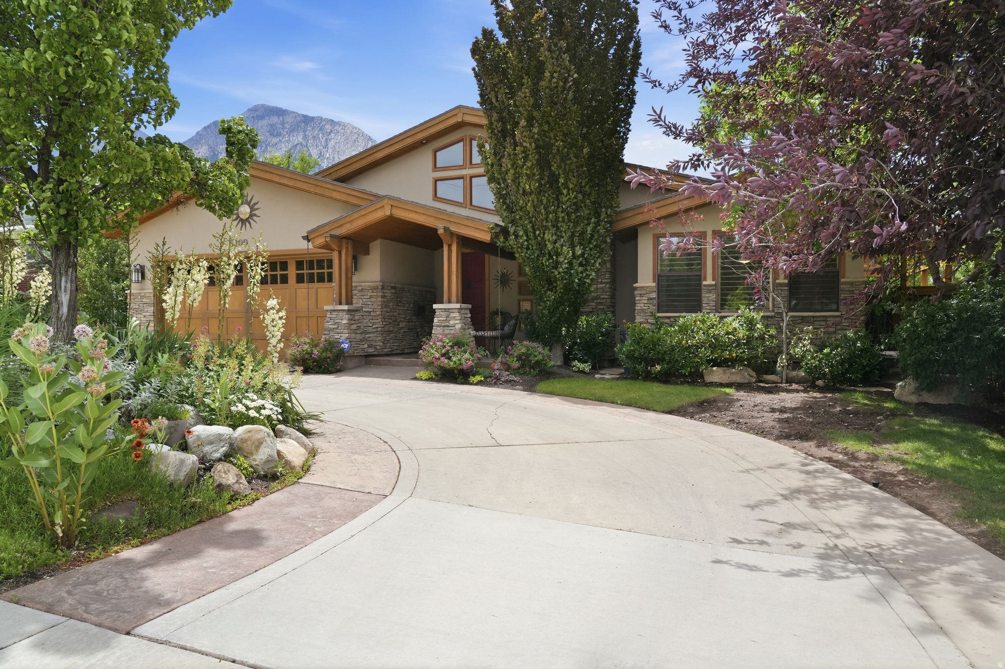 A truly distinctive residence where timeless architecture and modern design come together seamlessly. From the moment you step inside, soaring vaulted ceilings, expansive skylights, and stunning natural stone elements create an inviting atmosphere filled with warmth and character. Extensively remodeled and expanded in 2007, the home offers an open-concept layout centered around a beautifully appointed kitchen featuring a large island, granite countertops, a gas range, and a cozy gas fireplace. The flexible floor plan includes two spacious primary suites-one on the main level and one upstairs-making it ideal for multi-generational living, guests, or a variety of lifestyle needs. The home can also be easily converted into a four-bedroom residence. Designed for entertaining, the lower level features a wet bar and walkout access to a private backyard retreat. Take in spectacular views of Mount Olympus and the valley while enjoying the Trex deck, hot tub, raised garden beds, and mature landscaping that provide exceptional privacy and tranquility. Additional highlights include a fully fenced yard, abundant parking, and a convenient circular driveway. Approved by the city for short-term rental use, this one-of-a-kind property offers an extraordinary opportunity as either a private residence or investment property. Homes with this level of character, flexibility, and setting are rarely available