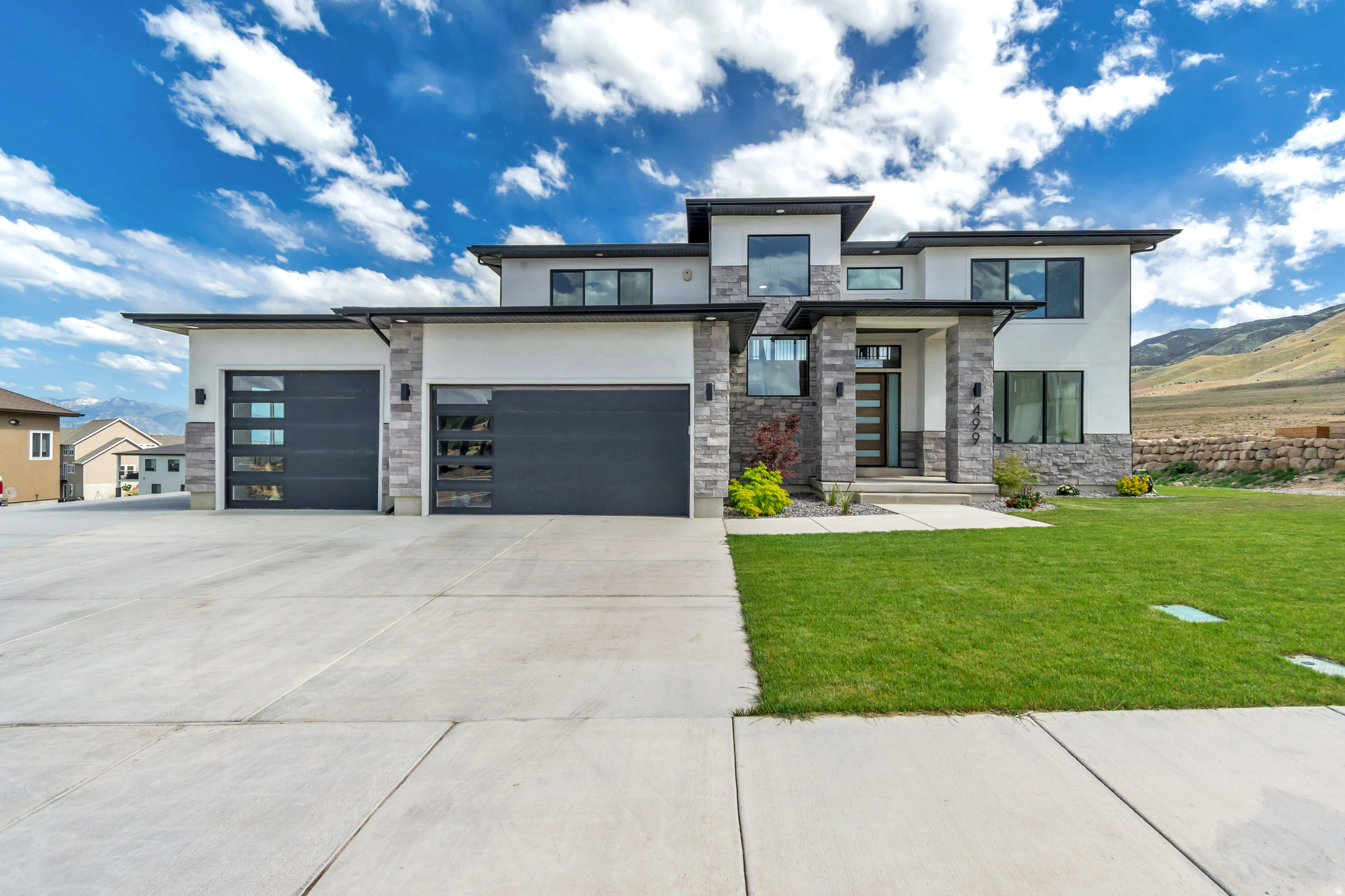 Stunning modern 2024 Saratoga Springs custom home featuring 4 bedrooms, 4 bathrooms, and breathtaking views of Utah Lake and the surrounding mountains. This one-of-a-kind home showcases exceptional architectural design, luxury finishes, and unforgettable custom details throughout. The open-concept layout is filled with natural light and features oversized countertops, perfect for entertaining, along with a stylish butler's pantry.  Unique features a hidden main bedroom entrance behind a bookshelf in the family room, which opens with a secret book latch The luxurious primary suite includes a private balcony where you can enjoy spectacular lake and mountain views. Additional highlights include a spacious 3-car garage and a thoughtfully designed lower level with future potential for a complete 2-bedroom, 1-bath mother-in-law apartment with its own independent entrance. Plans have already been approved by the city, making this an excellent opportunity for multigenerational living or future rental income. A rare blend of modern elegance, functionality, and custom design in one of Saratoga Springs' most desirable locations. WOOW Up tp $30,000 Incentive with an acceptable offer!!!