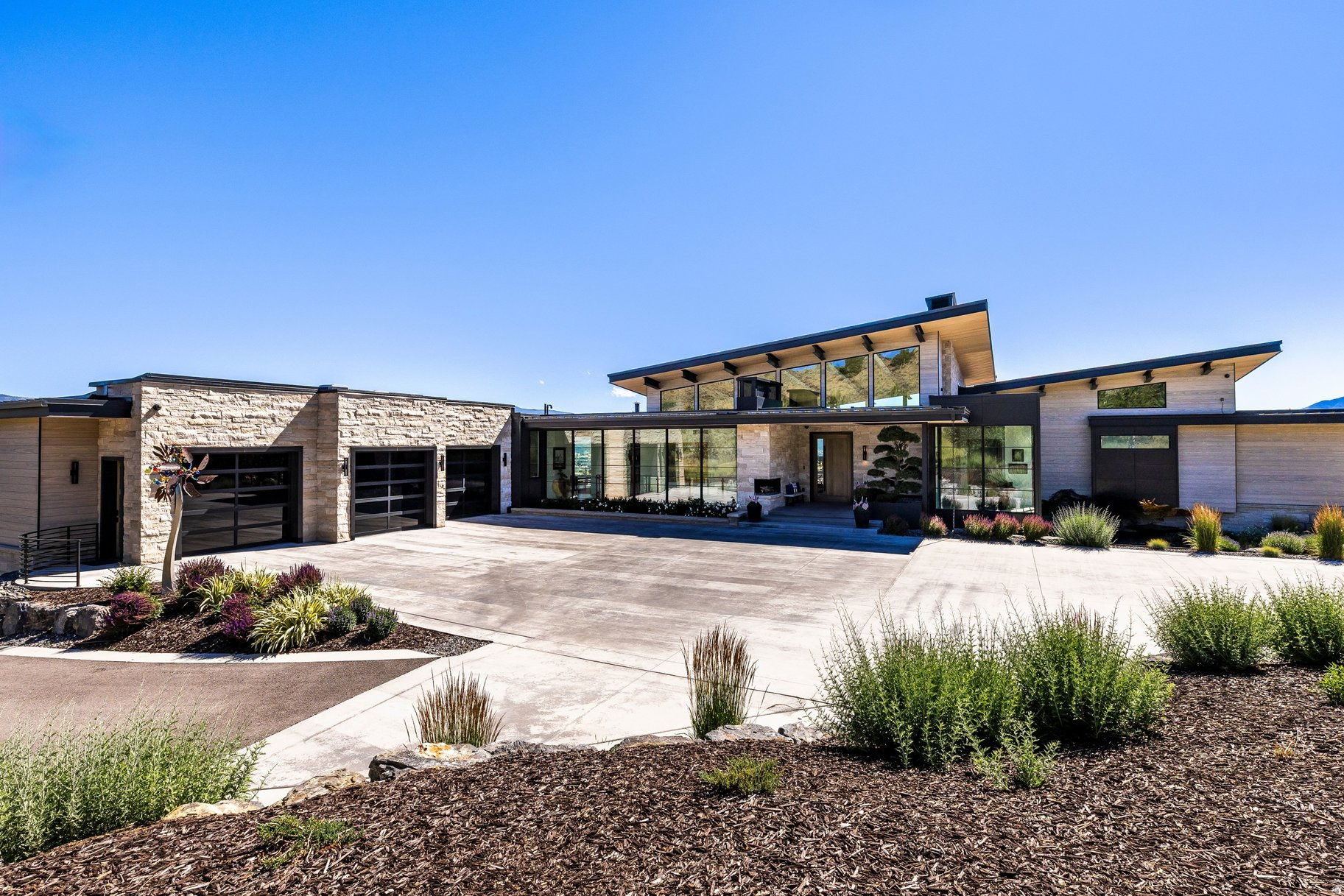 This custom architectural masterpiece, designed by Michael Upwall and built by Phelps Construction, sits on 1.93 acres with stunning west-facing views of Mt. Timanogos. Access is available to a full golf membership at Red Ledges with deposit. The residence showcases commercial-grade construction with full-stack imported stone, custom metal trim, and a two-dimensional roof that maximizes the property. Oversized hallways and doorways, an elevator, and 12' lower-level ceilings provide exceptional quality and accessibility. Inside, the dramatic great room features floor-to-ceiling windows, white oak flooring, invisible surround sound, and a striking full-length concrete and steel hearth fireplace. The gourmet kitchen offers Wolf, Sub-Zero, and Cove appliances, including a 60'' dual-fuel range, flowing into 1,100 sq ft of covered al fresco dining with a Wolf outdoor kitchen, gas firepit, and soft-serve ice cream machine. The lavish master suite includes a steam shower, sauna, free-standing tub, and massive custom closet system. Additional highlights include a 12-seat theater with premium sound system, fully equipped gym, and multiple guest suites. Outdoor living is resort-style with a 22' x 65' saltwater pool and spa, large jacuzzi, three outdoor fireplaces, maintenance-free artificial turf, golf practice green, ax throwing, outdoor bed swing, and bespoke water feature. The property includes a fully automated sprinkler/fertilization system and over 100 mature trees. Additional premium features include a massive 10+ car garage (1,900 sq ft main + 1,200 sq ft lower with lift), both heated with polyurea flooring and EV charging, plus a Fort Knox vault. Other luxuries: whole-home Generac generator, 360 surveillance, commercial fire suppression, five HVAC units with purification, heated driveway, hidden trailer pad, and full Control 4 automation. Luxury lives here.