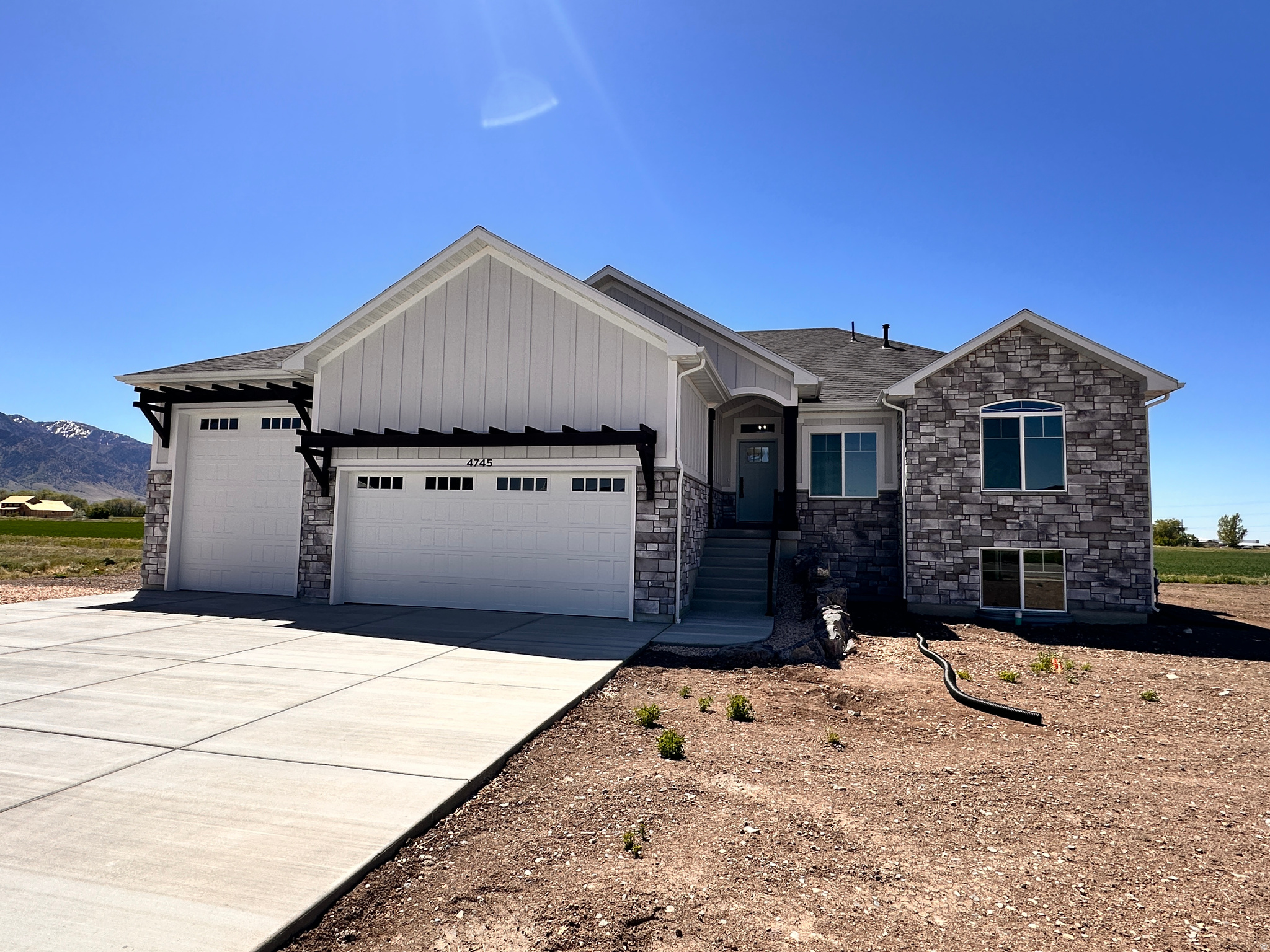 This stunning, custom-built residence sits on a spacious half-acre+ lot and delivers the best of Northern Utah living - breathtaking Wasatch Mountain views to the east and unforgettable sunsets to the west. The thoughtfully designed floor plan features a main-level master suite - 3 bedrooms, and 2 full bathrooms.  An additional 23 bedrooms, a bathroom, and a large open gathering space ready to be finished in the basement - offering incredible flexibility to grow into the space. At the heart of the home, the welcoming kitchen impresses with custom cabinetry, quartz countertops, an oversized island, and stainless steel appliances. The open-concept living area flows effortlessly onto a covered, south-facing deck - perfect for shaded entertaining, morning coffee, or quiet evenings year-round. Car enthusiasts and outdoor adventurers will love the oversized 3-car garage, epoxy floors, complete with a 12' door to accommodate all your toys, RVs, and equipment. This is more than a home - it's a lifestyle. Schedule your private showing today.