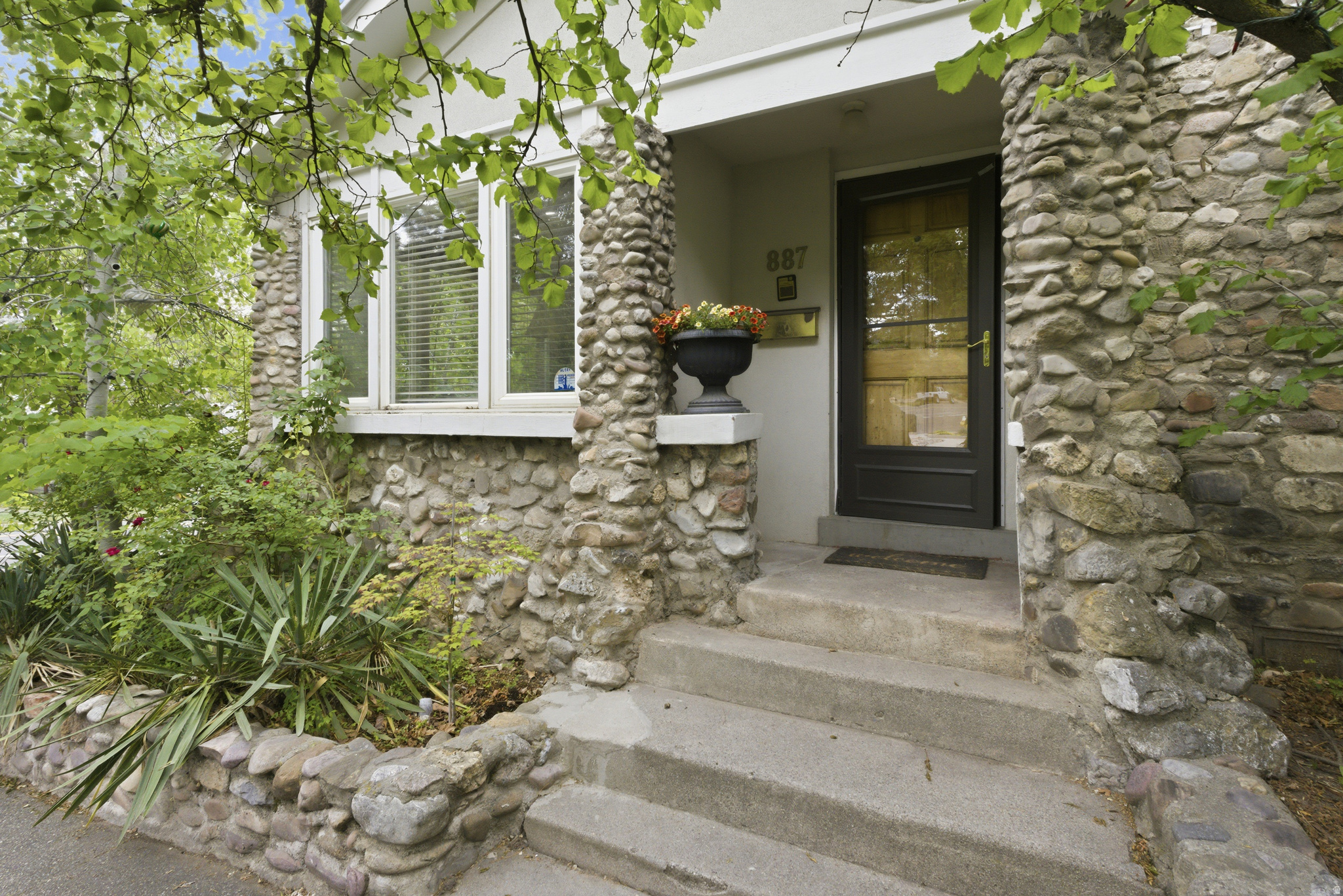 Built in 1891, this home has personality and character. From the locally sourced rock facade that carries inside with the stone gas fireplace, to the arched doorways and built in bookcases, there is a sense of charm that is unique to this house. The sunroom is a wonderful addition that brings in light and nature, along with the bay window in the dining room and the skylights in the kitchen. If you enjoy entertaining, this kitchen-dining- outdoor deck space is perfect for evening get-togethers and bbqs. The yard space is terraced and level, and the hot tub is included. Inside, there are three bedrooms with well designed layouts. Two of the three bedrooms capture loft space that creates multiple options for use. One of the bedrooms was once used as an ADU for students and short-term rentals allowing the property owner to earn extra income. The laundry-mud room is used for storage and has untapped potential. The unfinished basement houses the mechanicals. Water heater was updated in 2025 and the furnace was updated in 2020 & was recently serviced. There is even space for more storage or a possible man-cave or speak easy. Truly, this is one property you need to see in person.