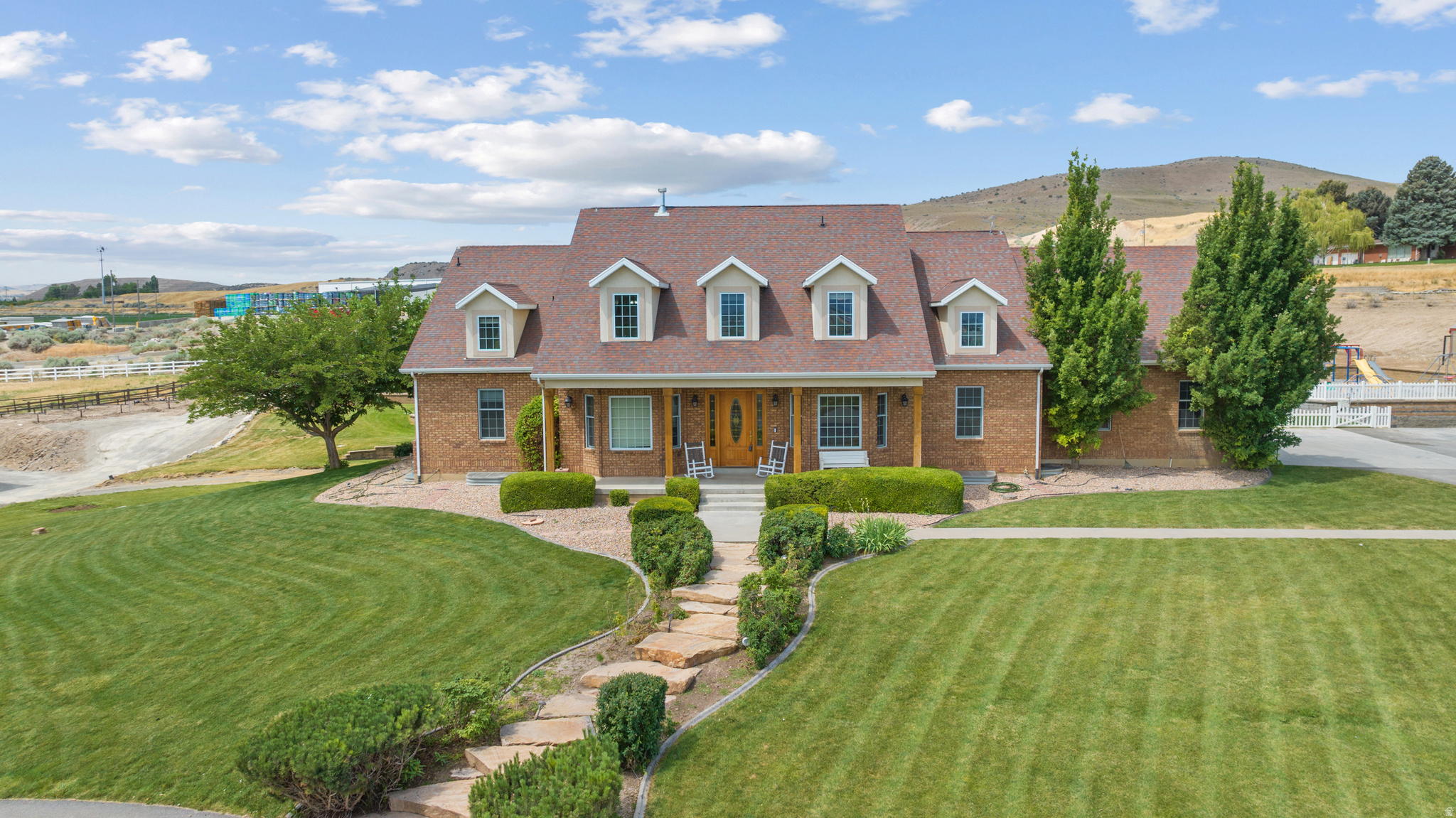 Beautiful 8,500+ sq ft home on 5.32 acres with stunning mountain & valley views! Features 8 beds, 5 full & 2 half baths, open kitchen with double ovens, 2 dishwashers & large pantry. Main-floor primary suite with walk-in closet & deck access. Finished basement with theater, kitchenette & separate entrance-ADU potential. New HVACs, tankless water heaters, fenced pasture,  two outbuildings- 30' x 60' with a 100-amp power service building and a 66' x 60' shop with 200-amp power. We are not done yet!  Greenhouse, grow boxes & root cellar. Zoned for horses/livestock, near trails. Assumable 2.87% VA loan (Approximately 900,000 -non-vets eligible).