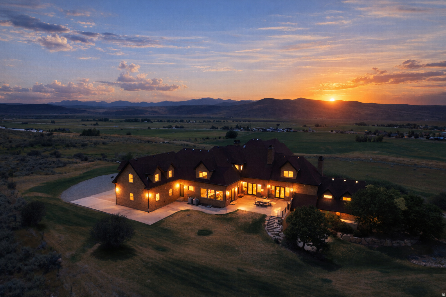 Tucked away at the end of a private gated road in the heart of Kamas Valley, this remarkable 17-acre mountain estate offers a harmonious blend of complete privacy, breathtaking natural beauty, and everyday convenience. Just minutes from the charming town of Kamas with its shopping, dining, and local amenities, and only approximately 20 minutes from Park City and Deer Valley's East Village, the property is thoughtfully designed for multi-generational living, unforgettable family gatherings, and luxury retreat Airbnb-style hosting. In addition to the main residence, the estate includes a beautifully appointed private guest residence with its own entrance, offering exceptional flexibility for extended family, guests, or rental opportunities. Offered fully furnished, the estate is ready to be enjoyed from day one. With its coveted west-facing orientation, the property enjoys what many consider to be some of the most spectacular sunsets in the Kamas Valley, as golden light washes across the Wasatch Mountains, Mount Timpanogos, Deer Valley's ski runs, and the rolling valley below, creating an unforgettable backdrop to everyday life.  Designed to capture its breathtaking surroundings, the home showcases soaring ceilings, expansive decks and patios, and timeless craftsmanship that frame panoramic views. Every space invites the outdoors in, creating a seamless connection between the home and its spectacular natural setting.  At the heart of the home, the grand great room enchants with a striking two-story fireplace framed by exquisite custom built-in bookcases and cabinetry, creating a warm and sophisticated focal point. Blending timeless craftsmanship with everyday functionality, the space invites family and friends to gather while French doors showcase the breathtaking mountain landscape above.  A second living room is equally captivating, featuring floor-to-ceiling windows, a charming window seat perfectly positioned to soak in the breathtaking mountain views, and double French doors that open onto a covered outdoor dining patio. Whether basking in the warm natural sunlight or watching fresh snow gently blanket the surrounding mountains, this inviting space offers a front-row seat to the beauty of every season.  The beautifully appointed chef's kitchen was designed for both everyday living and entertaining on a grand scale. It features dual refrigerators, abundant prep space, and an extraordinary magazine-worthy walk-in pantry that is as functional as it is beautiful. Whether preparing intimate family dinners or catering celebrations for large gatherings, the kitchen is truly the heart of the home.  The formal dining room creates an unforgettable setting for intimate dinners and holiday celebrations alike. A warm dual-sided fireplace adds ambiance while double French doors open onto the front patio, where elegant arched architecture beautifully frames the surrounding mountain vistas and spectacular sunsets, creating a seamless extension of the dining experience outdoors.  The main level was thoughtfully designed for convenient single-level living. In addition to the luxurious primary suite, two generously sized guest bedrooms are located on the main floor, allowing family and guests to enjoy effortless accessibility.   The primary suite is a true private sanctuary. Spacious and beautifully appointed, it features double French doors opening directly onto a patio with breathtaking mountain views. A private adjoining library or office is warmed by its own fireplace offering a peaceful space to work or unwind. The spa-inspired bath features a soaking tub, oversized walk-in shower, dual vanities, and an expansive custom walk-in closet with extensive built-ins, creating a luxurious retreat.   Designed for both privacy and flexibility, the home also includes a beautifully finished private guest residence with its own separate entrance, private 2-car garage, and workshop above. This exceptional living space features a beautiful kitchen, wel