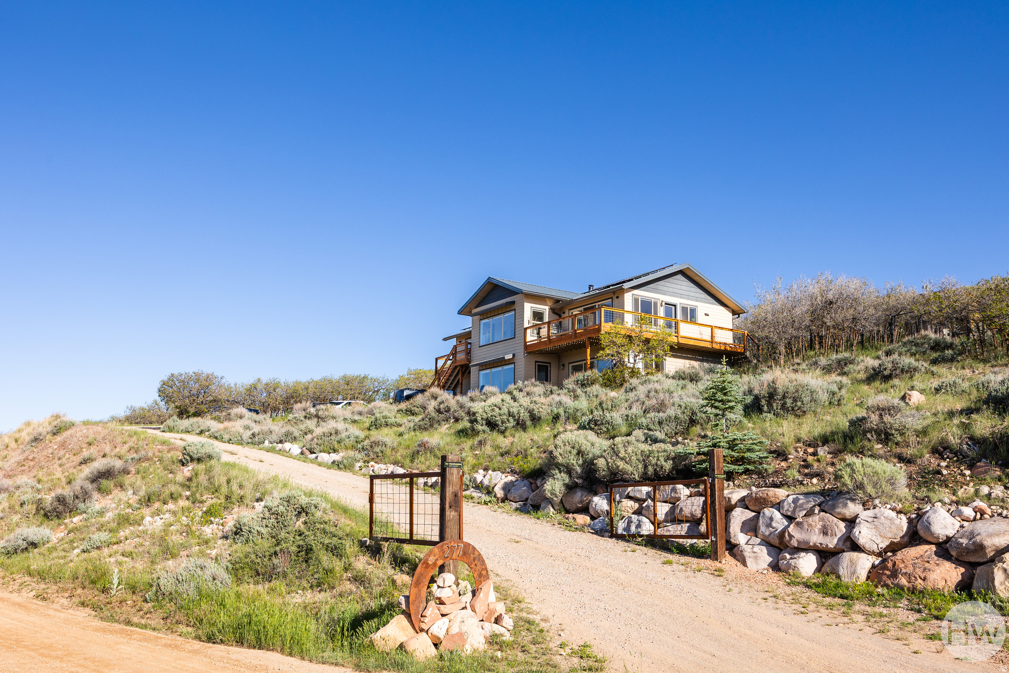 This is a lakeside community property that asks you to slow down a bit. Situated at Rockport Estates near Park City, this double-lot (2 acre parcel) home has panoramic views of the ridge line of the Wasatch back from Canyons Resort to PCMR and Deer Valley, as well as part of the Uinta Range, as a backdrop, so we're guessing you'll be more than happy to take a beat here. The two story layout is well-designed and cozy, with vaulted ceilings in the main living spaces, an open flow, and the kind of natural light that makes every room feel bright and welcoming. A modern style makes each space feel clean and spacious, and the kitchen is well-appointed with granite countertops and a large island for easy prep and entertaining. Upgrades here go well beyond cosmetic-solar panels, a Tesla Powerwall (capable of keeping the home running for up to 10 days off-grid), an EV charging station, aluminum roof, and four 3,000-gallon (12,000-gallons) water cistern tanks (quadruple the capacity of other homes in the community)-mean this property is as practical as it is beautiful. Outside you'll find decks for lingering with a cup of coffee, a greenhouse for your growing needs, three fire pits for nights spent with friends, a chicken coop for the hens in your life (note: they can be included in the sale), and a natural landscape of scrub oak that keeps things feeling perfectly wild. No matter the level of the home, there's patio access, and RV parking leaves space for your home away from home, should you need it. Residents here can rest easy, as HOA covers road maintenance and water supply, and AG-80 zoning keeps your options open. And, since you're located close to the reservoir, the mountains, and the amenities of Park City, we'd say this one is more than ready for its next lucky owners. Square footage figures are provided as a courtesy estimate only. Buyer is advised to obtain an independent measurement.