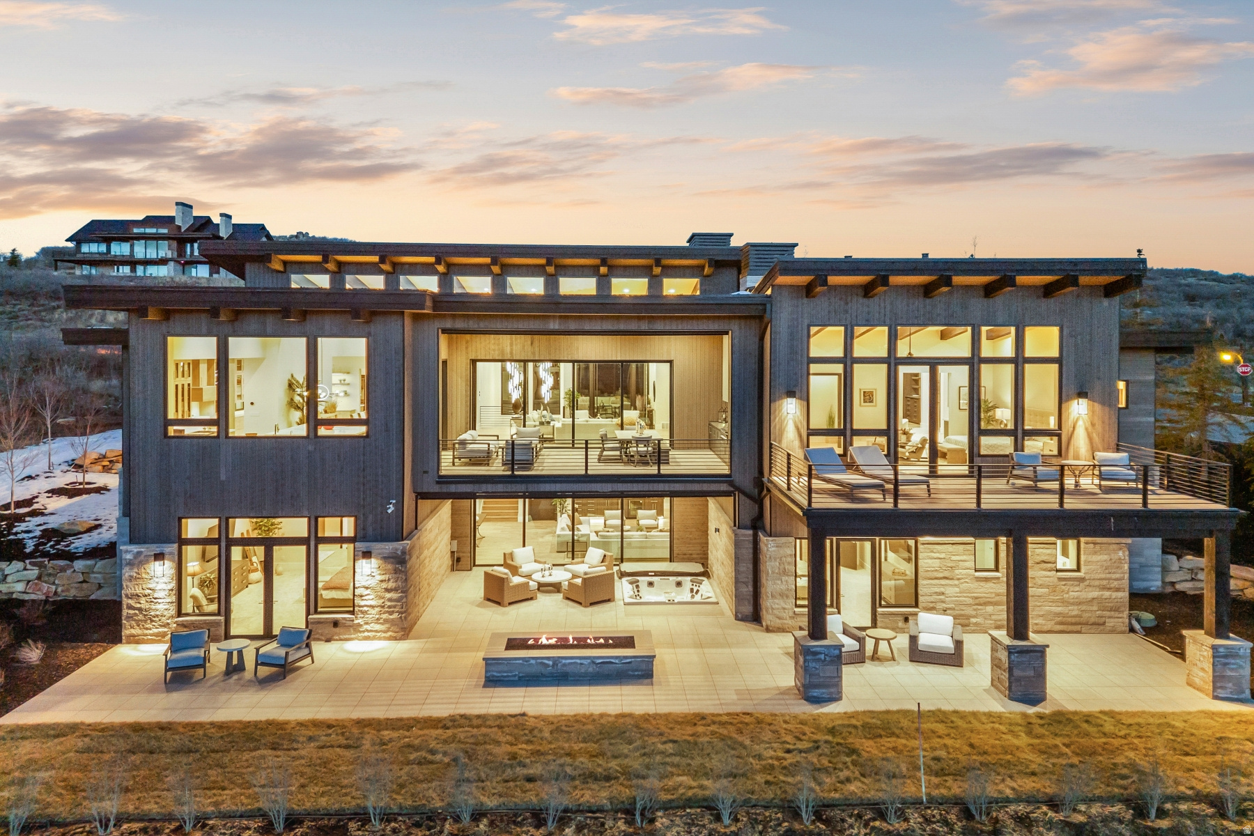 Positioned above Tuhaye's Dancing Sun enclave, this refined mountain contemporary captures panoramic views across the Wasatch Back, including the expanding Deer Valley East Village. Designed by Scott M. Grunst and built by Mountain High Custom Homes, the home blends modern architecture with warm, natural materials and exceptional livability. Vaulted ceilings and expansive window walls flood the open floor plan with light, framing dramatic sunsets over Deer Valley. The chef's kitchen is equipped with Wolf, Sub-Zero, and Bosch appliances, a full butler's pantry, and dual wine refrigerators, seamlessly connecting to generous indoor and outdoor entertaining spaces with heated decks, fire features, and a private hot tub. The primary suite offers a true retreat with dual dressing rooms and a spa-level bath. Multiple laundry areas, a flexible lower level, and thoughtful sound insulation throughout enhance comfort and functionality. Located within the private Talisker Club community, with four-season amenities and golf, and just minutes to the new Deer Valley East Village, this is a rare opportunity to own a view-forward, design-driven home in one of Park City's most coveted settings.