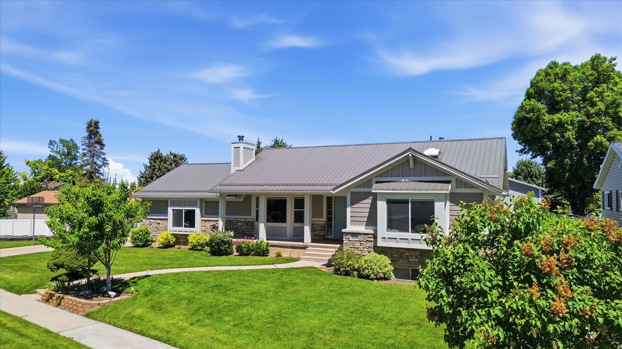 This beautiful single-owner home has been lovingly maintained for years and now greets you with a show-stopping exterior remodel that feels fresh, upscale, and built to last. Hardy board siding, elegant stone accents, and a sleek metal roof give it curb appeal, while the added exterior insulation delivers excellent energy efficiency-keeping you comfortable and your bills lower year-round. Inside, the layout feels comfortable and practical for everyday living.  The kitchen opens right into a big, bright sunroom that gets tons of natural light. It's a wonderful spot for reading books, family meals, or just relaxing. The primary suite includes a nice walk-in shower, and the home offers four bedrooms total, a separate den, and three bathrooms-plenty of space for everyone. The large family room is a favorite gathering spot, with a wood-burning fireplace that makes evenings extra cozy. Right off the family room in the basement you'll find a handy craft room/office-perfect for hobbies, work, or quiet time. You'll also appreciate the two-car garage with good storage, raised garden beds out back ready for your plants or vegetables, and extra storage space throughout the basement and garage. This comfortable home combines modern exterior updates with a warm, livable interior that's ready for your next chapter. Best of all, it's centrally located near shopping, stores, and USU-making daily life even more convenient. Come take a look and see if it feels like home-schedule your showing today!