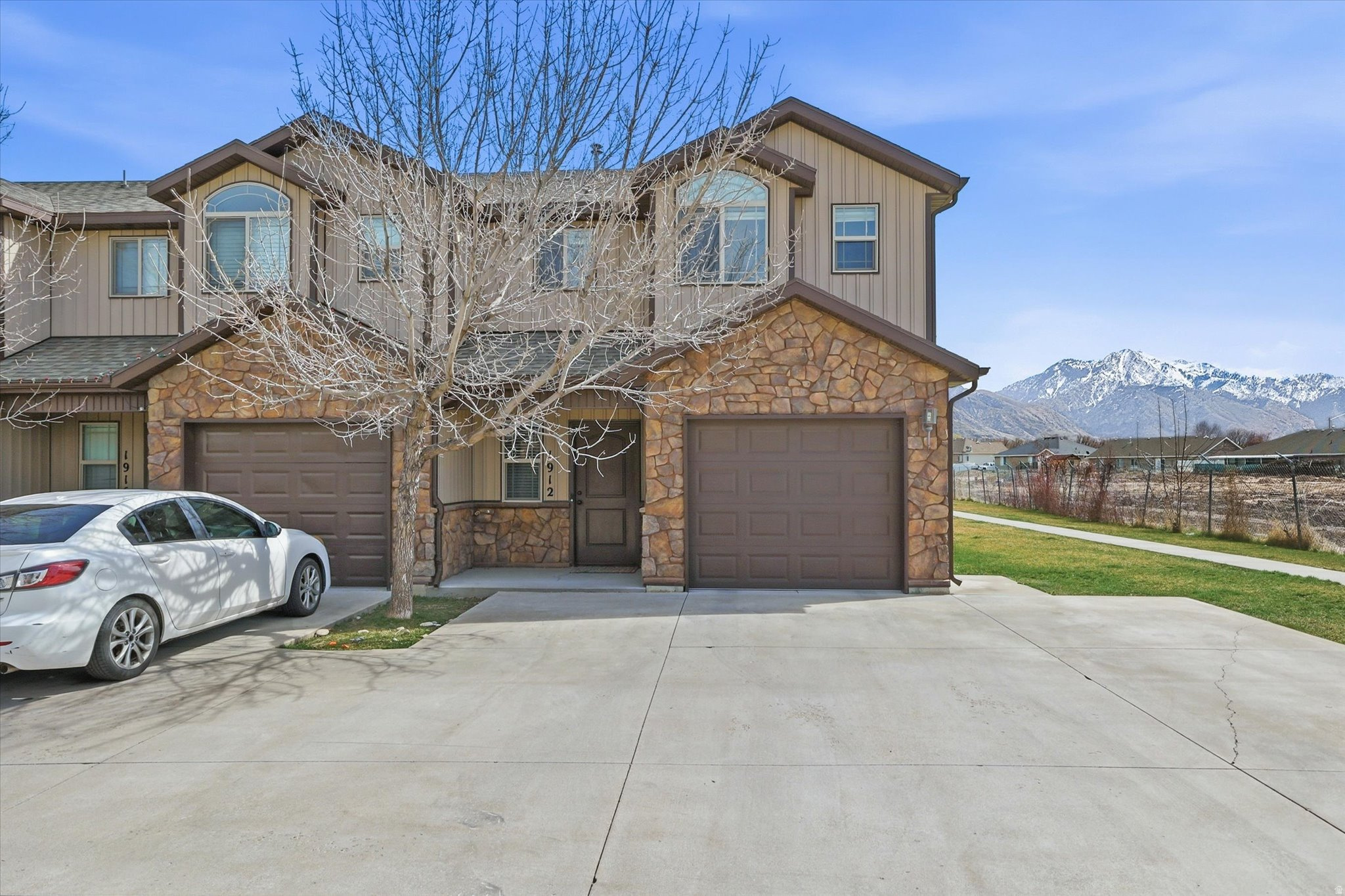 Well-maintained end-unit townhome in Golfcrest Village with beautiful mountain views and a larger backyard featuring a concrete patio. The open floor plan connects the kitchen, dining, and living areas and includes a breakfast bar, pantry, and all appliances included. The home offers a spacious primary suite, dedicated laundry room, LVP flooring in the living room, and tile in the kitchen and bathrooms. Enjoy morning sun from the back patio and evenings on the covered front porch. Additional features include an attached garage with extra storage and two additional parking spaces. Convenient location close to parks, shopping, and everyday amenities.