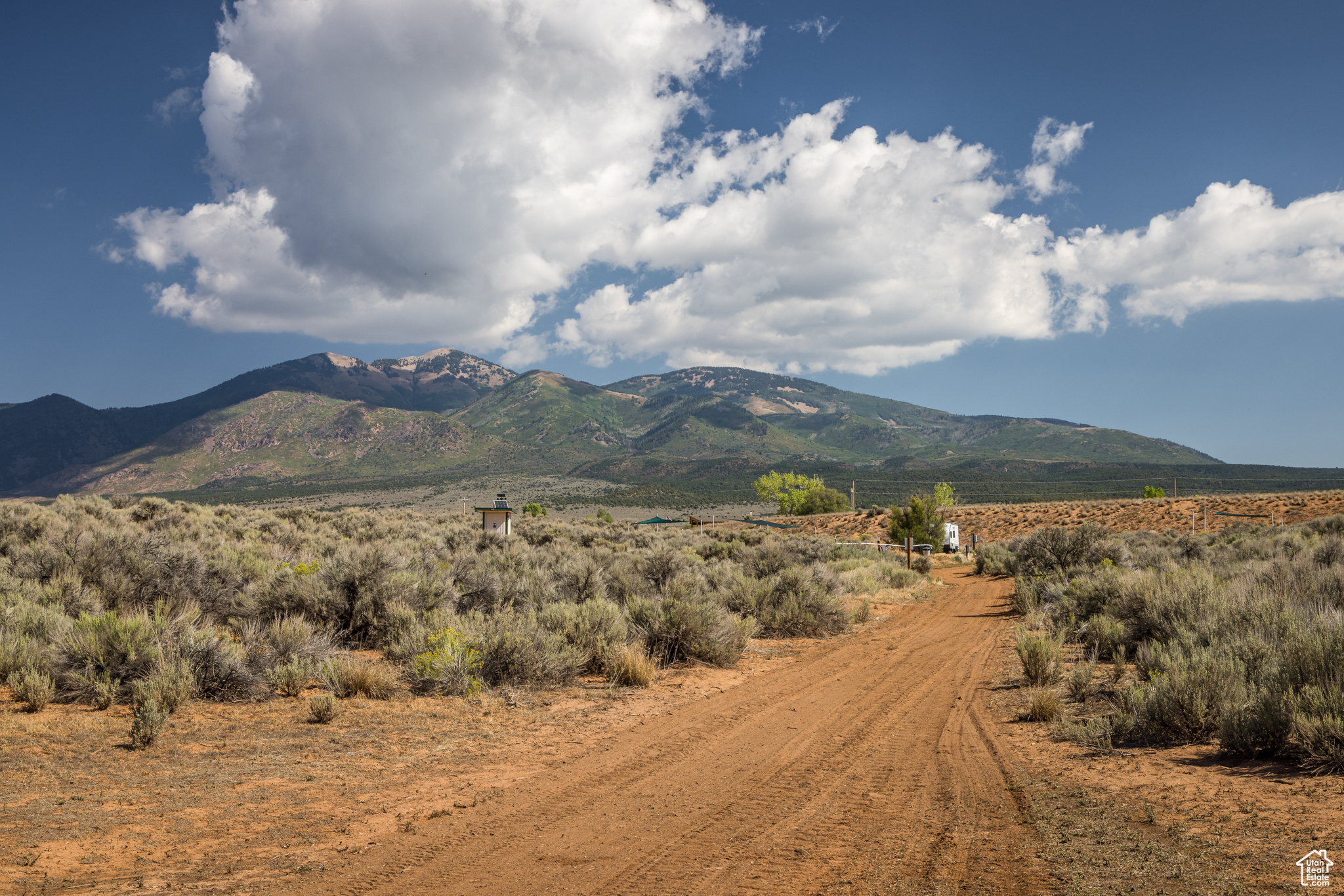 Bask in views of three mountain ranges from your campsite or custom home, the La Sal Mountains, the Abajo Mountains and the Henry Mountains. A dry pond bed and mature trees create an earth wall of privacy and protect your viewshed of the La Sal Mountains. There are many ways to enjoy this fully fenced 39-acre parcel. The gravel road from the gate leads to a campground with four established sites and a caretaker site that has rave reviews. Each site includes a fire pit, picnic table and shade arbors. There is also a pit toilet and trash receptacles. A sophisticated well house has 3200 watts of solar on the roof and there is currently enough power to expand to twenty sites. Six acres dry pasture and one acre of irrigated pasture encourage deer and other wildlife. The land is also subdividable, which creates even more options.