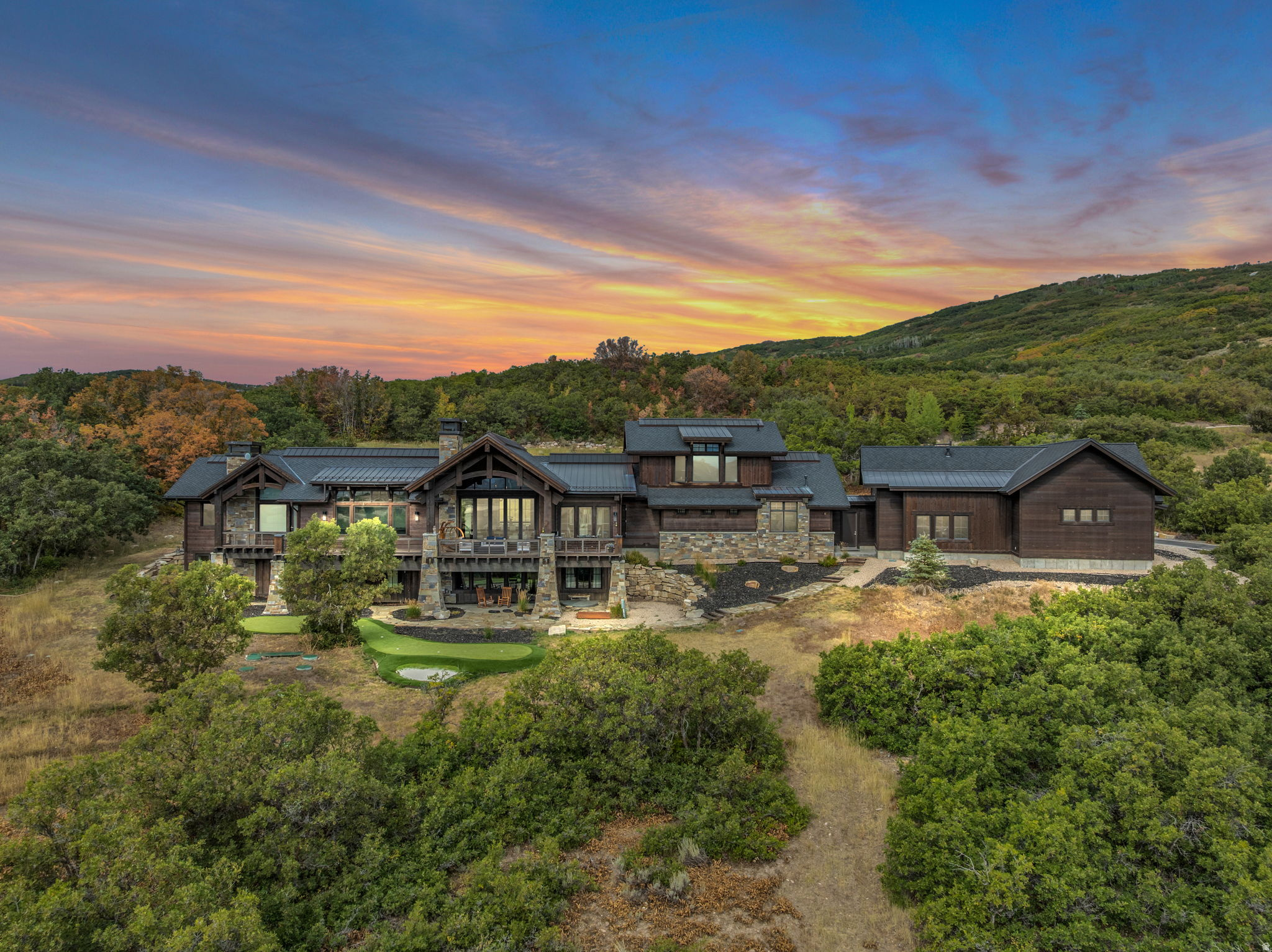 Located on over 10 acres in the gated community of The Preserve, this estate combines elegance, privacy, sophistication, and panoramic views with a new level of functionality for the ultimate mountain lifestyle. Since its purchase, the property has been significantly enhanced with a 2,400-square-foot shop garage, designed to accommodate up to 8 additional cars or a large motorhome plus multiple vehicles, this one-of-a-kind space is complete with a car lift and premium features, making it a true dream garage for car collectors and outdoor enthusiasts alike. The main residence showcases an open layout with all the right spaces for both family living and grand entertaining, including a chef's kitchen, bar/sports room, sleek wine cellar, and fitness room. A spacious safe room provides secure storage for collections, while the executive office occupies its own private level, offering a quiet retreat for productivity, or the flexibility to serve as an additional guest suite. The exterior grounds reflect a fresh, thoughtful approach to mountain landscaping. Highlights include a private putting green, in-ground hot tub, fire pit, and multiple patios designed for year-round outdoor entertaining. Wildlife is a daily presence, with elk, deer, and moose often roaming nearby. Direct access to Flying Dog and The Preserve's extensive trail system allows for endless opportunities to hike, mountain bike, and snowshoe straight from your backyard. For road cyclists, the property's location offers direct access to Park City's scenic routes. Convenience remains unmatched: only 10 minutes to Kimball Junction, less than 20 minutes to Park City Historic Main Street, Park City Mountain Resort, and Deer Valley Resort for world-class skiing, dining, and shopping, and only 35 minutes to Salt Lake City International Airport. All located within the Park City School District. The property also allows for the future construction of a guest house.