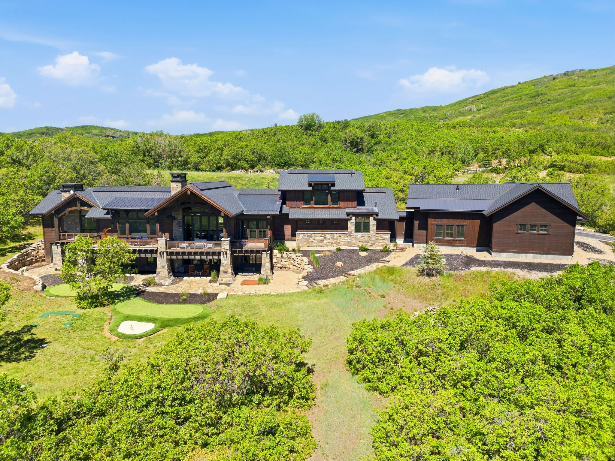 Located on over 10 acres in the gated community of The Preserve, this estate combines elegance, privacy, sophistication, and panoramic views with a new level of functionality for the ultimate mountain lifestyle. Since its purchase, the property has been significantly enhanced with a 2,400-square-foot shop garage, designed to accommodate up to 8 additional cars or a large motorhome plus multiple vehicles, this one-of-a-kind space is complete with a car lift and premium features, making it a true dream garage for car collectors and outdoor enthusiasts alike. The main residence showcases an open layout with all the right spaces for both family living and grand entertaining, including a chef's kitchen, bar/sports room, sleek wine cellar, and fitness room. A spacious safe room provides secure storage for collections, while the executive office occupies its own private level, offering a quiet retreat for productivity, or the flexibility to serve as an additional guest suite. The exterior grounds reflect a fresh, thoughtful approach to mountain landscaping. Highlights include a private putting green, in-ground hot tub, fire pit, and multiple patios designed for year-round outdoor entertaining. Wildlife is a daily presence, with elk, deer, and moose often roaming nearby. Direct access to Flying Dog and The Preserve's extensive trail system allows for endless opportunities to hike, mountain bike, and snowshoe straight from your backyard. For road cyclists, the property's location offers direct access to Park City's scenic routes. Convenience remains unmatched: only 10 minutes to Kimball Junction, less than 20 minutes to Park City Historic Main Street, Park City Mountain Resort, and Deer Valley Resort for world-class skiing, dining, and shopping, and only 35 minutes to Salt Lake City International Airport. All located within the Park City School District. The property also allows for the future construction of a guest house.