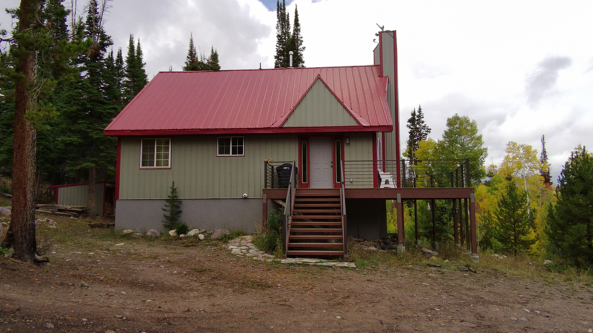 This property offers exceptional privacy, from the main road and is surrounded by pines and mountain views. The cabin offers plenty of room to host friends and family. With 4 bedrooms, two full bathrooms, a fun loft space, and a large family/game room in the basement, you can have a crowd and not feel crowded. Outside offers a great deck with a view, a firepit area, and 5 outbuildings to store your ATVs and tools.  The metal roof and siding are tasteful and practically maintenance free.   This cabin comes with a seasonal share of water and a cistern system that accommodates winter water needs.  This is property is located in the Manor Lands gated community near the Christmas meadows area of the Uinta mountains.