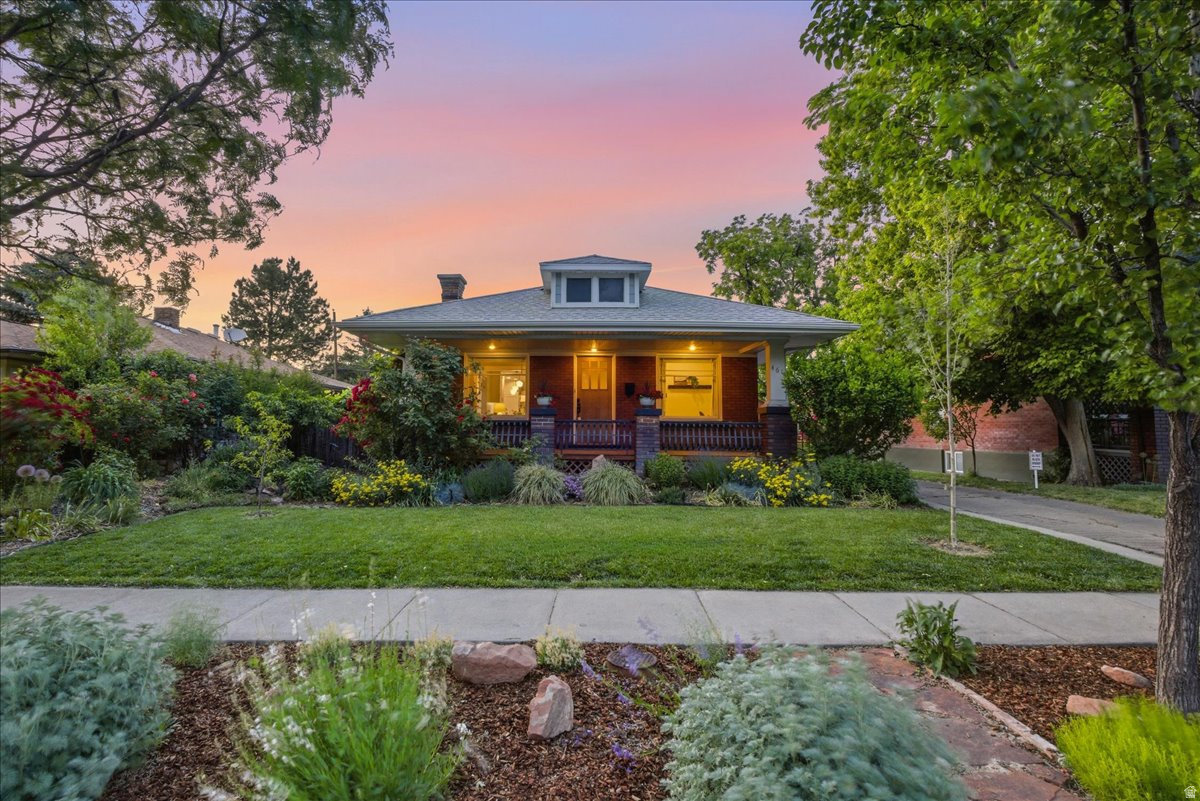 This Liberty Wells bungalow has been carefully cultivated for year-round comfort. From its impressive curb appeal to its extensive structural updates, this home perfectly blends original elements with peace of mind. Summer evenings are best spent relaxing on the large covered front porch or unwinding on the private redwood deck in the backyard. Inside, the home remains a cool sanctuary during the warmer months thanks to a smart-thermostat-regulated central air system and a naturally comfortable basement level. When the temperature drops, your comfort is equally assured. You can come home from a day on the slopes to soak in your backyard hot tub, or step onto the cozy, heated tile floors of the remodeled kitchen. The interior showcases original maple and Douglas fir hardwood floors throughout. The bright and open kitchen is equipped with premium stainless steel Bosch appliances and sleek black granite countertops. A thoughtful rear extension adds a convenient mudroom and generous square footage to the primary bedroom. The main-level bathroom was remodeled in 2021 with modern finishes and a dual vanity. Downstairs features a separate entrance, a dedicated laundry room with a utility sink, and clever built-in storage. The HVAC system was updated in 2018, and the historic radiators were intentionally left in place, offering the rare and flexible option to install a modern boiler for radiant heat instead of forced air. The outdoor space is a private, fully fenced oasis with a sprinkler system servicing, and dedicated garden area. Colorful blooms surround the yard from spring through fall, complemented by apple, nectarine, and peach trees. A brand-new shed installed in 2026 provides excellent additional storage. Beyond its aesthetic appeal, a comprehensive list of high-value improvements has been completed in recent years to maximize efficiency and structural integrity. A full seismic retrofit was completed in 2025, alongside a basement remodel featuring new windows and a radon mitigation system. Additional noteworthy updates include a new roof and a 3.3 kW solar array installed in 2018, enhanced attic insulation, a water softener, and durable Hardie siding on the back of the home. Perfectly situated on a quiet, tree-lined street just around the corner from Liberty Park, this vibrant location offers incredible walkability to a wonderful mix of local shops, cafes, and eateries.