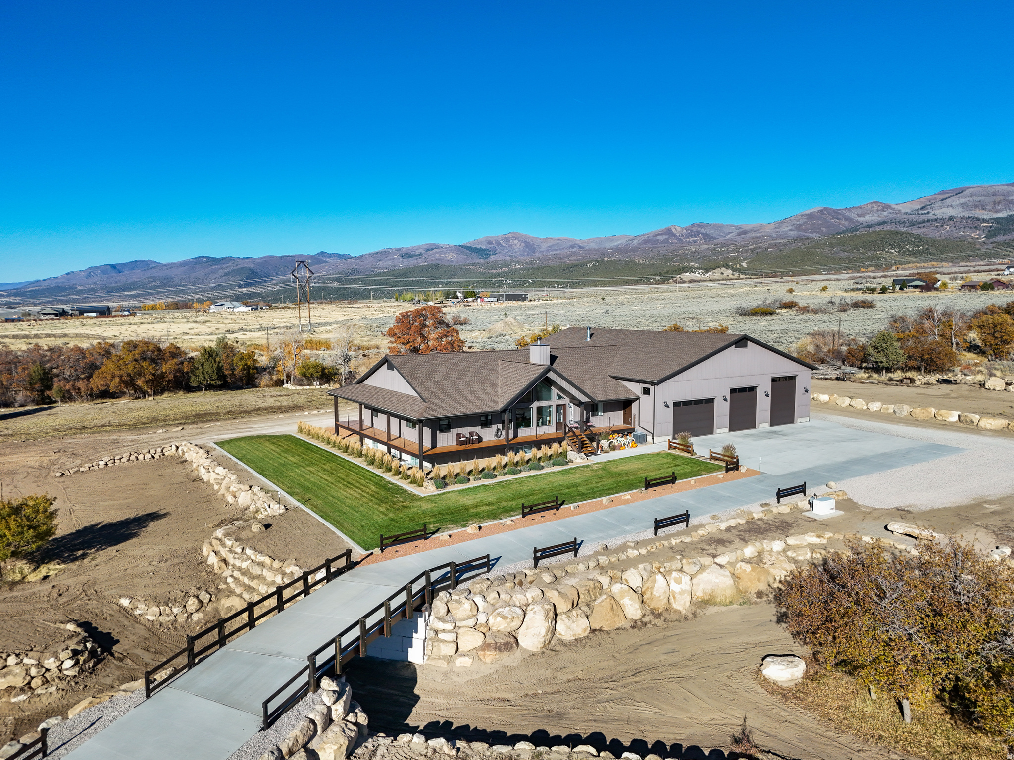 Come See! Private Mountain Estate on 5.2 Acres | 10-Car Garage | Luxury, Space, Sustainable Living | Hidden among the beauty of Utah's mountain landscape sits a truly rare opportunity to own a private custom estate designed for those who value freedom, space, and possibility. Situated on 5.26 acres with a seasonal stream, this one-of-a-kind property offers breathtaking views, peaceful wildlife, and the ability to create a lifestyle few homes provide.  As you arrive, a stunning concrete driveway crosses a charming bridge, welcoming you into a setting that feels worlds away from the everyday. The property unfolds into wide open space, towering skies, and the quiet serenity of nature. The centerpiece of this remarkable estate is the impressive 4,400+ sq ft heated garage and workshop with room for up to 10 vehicles with full RV hookups. Thoughtfully designed with a lift, workshop, loft, kitchenette, washer & dryer hookups, gym, and a 3/4 bathroom, wood burning and propane heater, this extraordinary space opens the door to endless possibilities. Whether you are a collector, automotive enthusiast, entrepreneur, creative builder, or someone who loves to host large gatherings, retreats, or masterminds, this space transforms imagination into reality. Inside the home, the open-concept living and kitchen area captures sweeping views through large windows on both the north and south sides, allowing gorgeous mountain and valley views, bringing the outside in and creating a warm, inviting environment for entertaining or relaxing as deer quietly pass through the property.  Encircling the home is a magnificent heavy timber wrap-around porch with deep overhangs, offering multiple outdoor living areas to enjoy morning sunrises, peaceful evenings, and star-filled mountain skies. The space easily accommodates outdoor seating, dining, or even a future hot tub overlooking the landscape.  The luxurious primary suite provides a private retreat with a sitting area, walk-in closet, spa-inspired soaking tub, and beautiful walk-in shower.  The fully finished basement offers exceptional flexibility with a spacious family room, two large bedrooms, a flex roof to add an additional bedroom, and four generous storage rooms. A thoughtfully designed mechanical room adds efficiency and accessibility to the home's infrastructure.  Additional highlights include:   Pole barn for equipment, firewood, RVs, or recreational vehicles  Three RV hookups ideal for guests or additional use  Permanent year-round lighting   ADA Accessibility.  This estate was created for those who dream bigger - those who want room to build, create, host, and live life on their own terms. Whether you envision a private retreat, collector's compound, apocalypse preparer, hobbyist haven, or a gathering place for unforgettable events, this property delivers unmatched versatility in a breathtaking setting.  Rarely does a property combine acreage, views, massive garage space, and custom living in such a compelling way. Private showings available with proof of funds or pre-approval. Square footage figures are provided as a courtesy estimate only and were obtained from blueprints. Buyer is advised to obtain an independent measurement. Information deemed reliable but not guaranteed; buyer and buyer agent to verify all information. Imagine walking into a fully furnished home, which is an option sellers are willing to discuss.