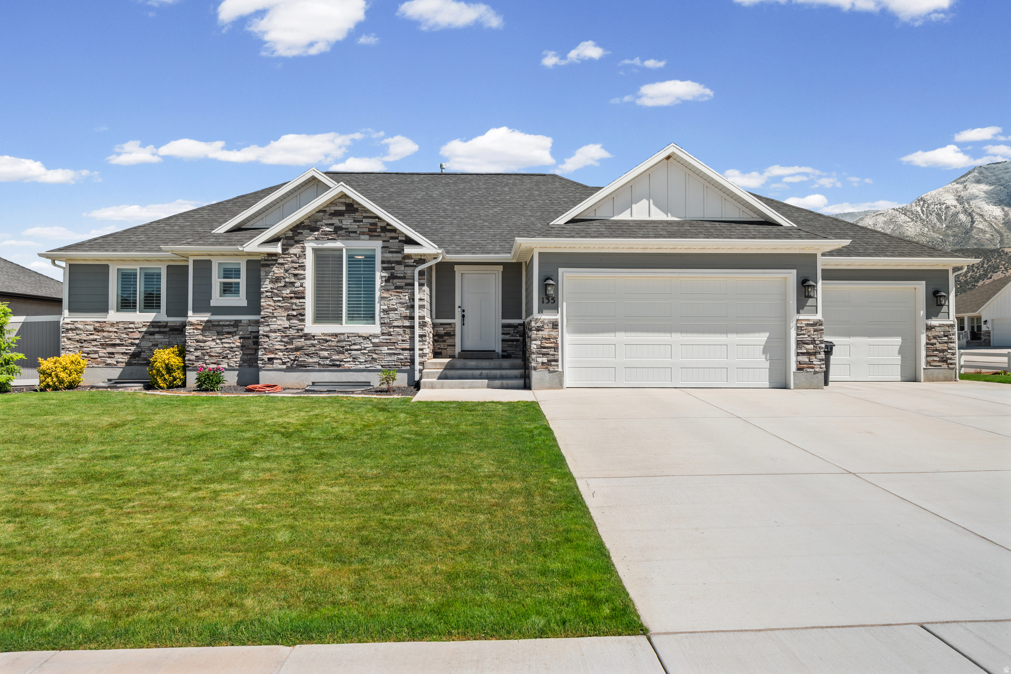 Welcome to this beautifully finished 3,188 sq. ft. home located on a desirable south facing corner lot, offering the perfect combination of comfort, functionality, and curb appeal.  The south facing orientation helps make winter snow removal easier while providing excellent natural light throughout the year.  Featuring 6 bedrooms and 3.5 bathrooms, this home provides plenty of space.  The fully landscaped front and back yards are equipped with automatic sprinklers designed for easy maintenance and outdoor enjoyment.  The vinyl fenced backyard includes planter boxes, a storage shed, and a covered back patio ideal for relaxing or entertaining year round.  Inside you'll find a thoughtfully designed layout featuring a walk-in basement and a dedicated beauty salon space, offering excellent flexibility for a home business, studio, bonus room or for creating a future potential kitchen and Accessory Dwelling Unit.  The insulated and painted 3-car garage is a standout feature, complete with professionally finished floors and two solid work benches, making it perfect for projects, storage or hobby space.  Additional upgrades include stone and cement board siding surrounding the entire home, fiber internet directly to the house, a water loop system for instant hot water, and window well covers for added convenience and protection.  This move-in ready home combines quality finishes, practical upgrades, and exceptional outdoor space in one impressive package.