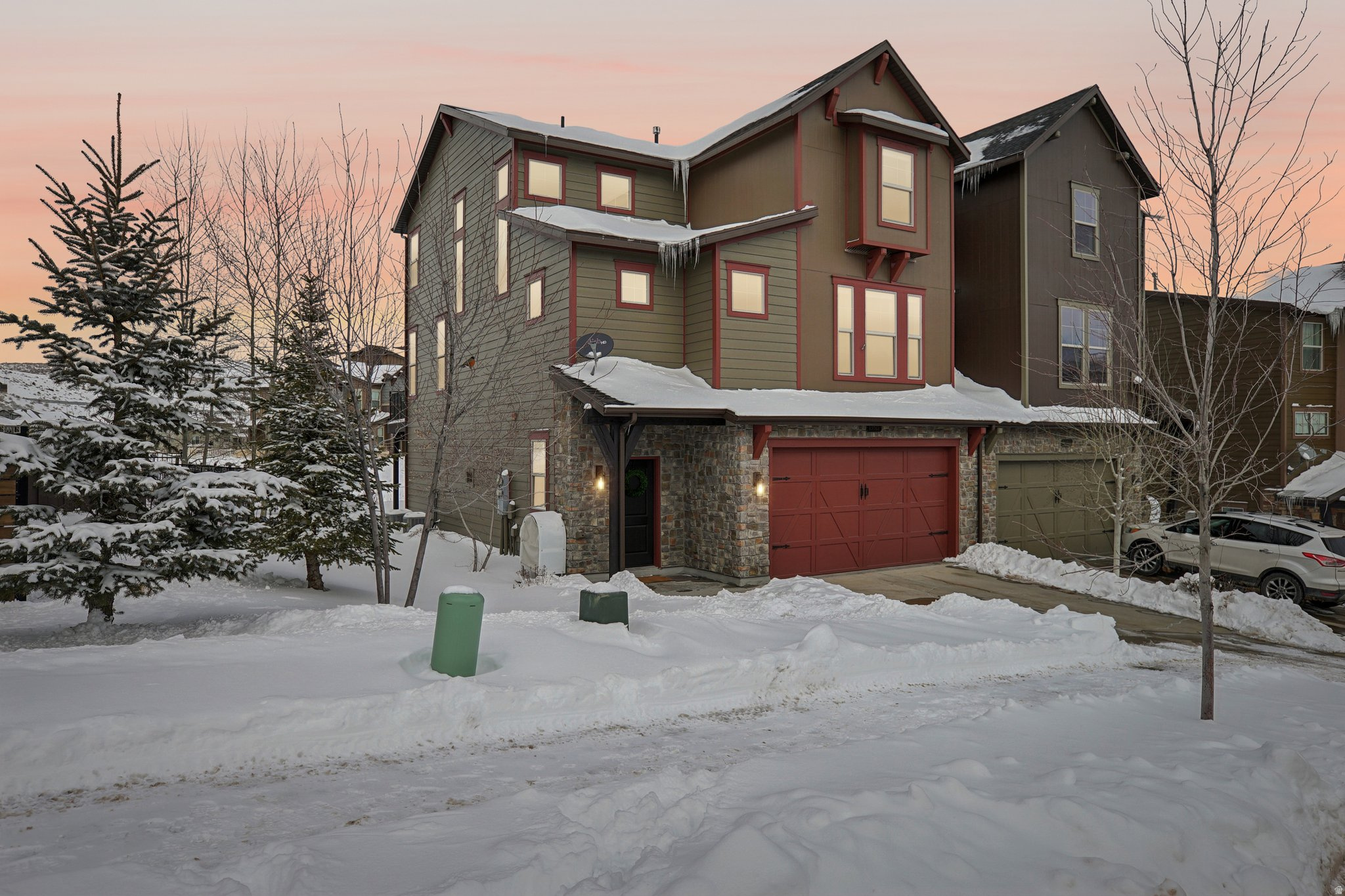 Ten minutes to Main Street and Deer Valley. The Retreat at Jordanelle gets you close to Park City without the resort premium.  Four bedrooms across three levels. Primary suite on the main floor, two more upstairs, and a fourth on the lower level that works like a separate guest suite. Vaulted ceilings in the living room with a stone fireplace and that upper-level balcony overlook. Wood floors throughout. Kitchen has quartz countertops, stainless appliances, and an island that actually seats people.  Recent updates include a new hot water heater and refrigerator. The garage is deep enough to park and still have room for bikes, skis, and whatever else you're hauling around-plus there's overhead storage already installed.  The HOA covers exterior maintenance and snow removal, plus access to the clubhouse-pool, hot tub, fitness center, and theater room.   Nightly rentals are permitted, which gives you options-live here year-round, use it as a second home, or rent it out when you're not around.  Jordanelle Reservoir is close. So are Deer Valley and Park City Mountain Resort. You're getting Park City access without paying for a Main Street or slope-side address.