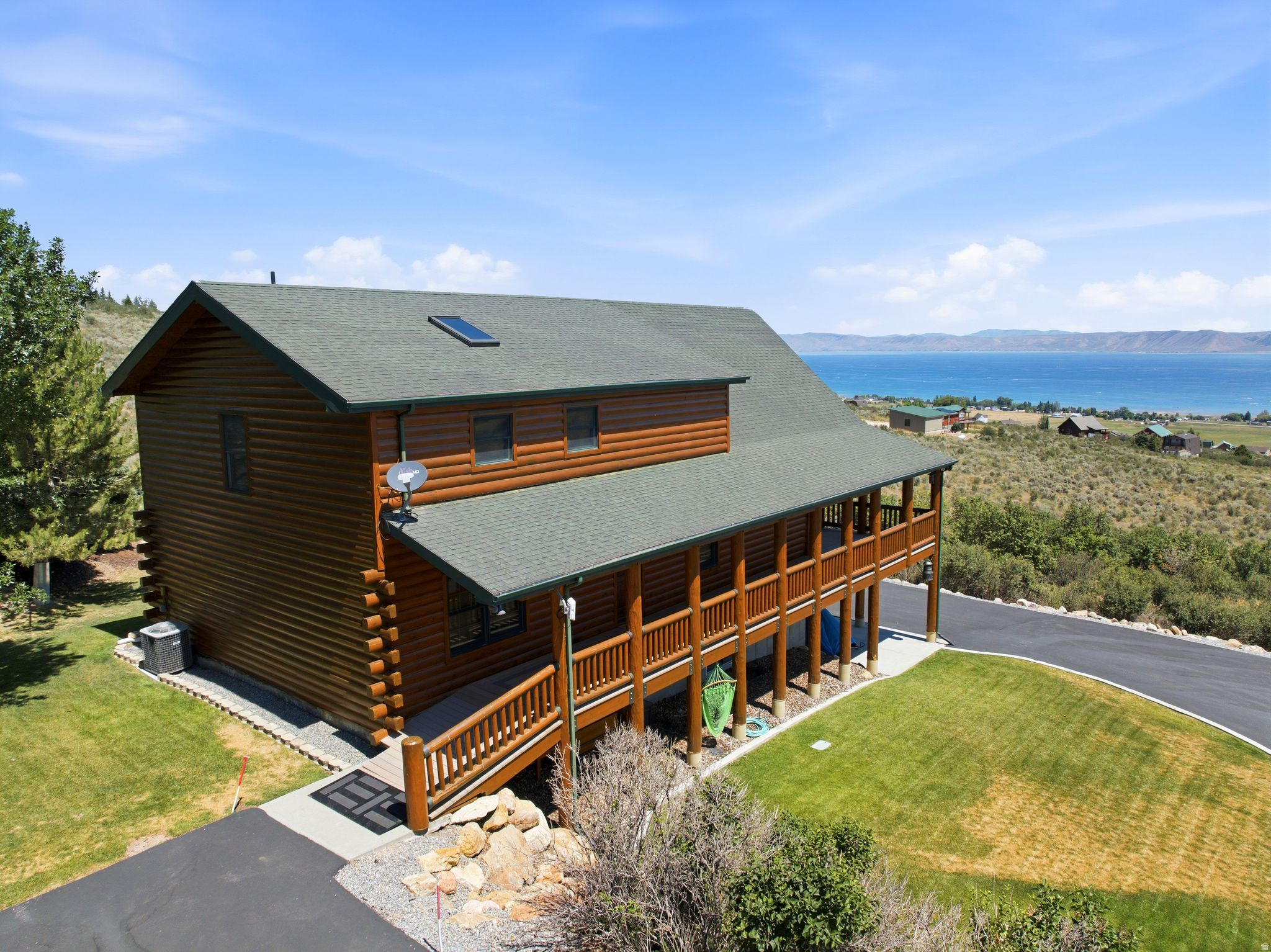 Escape to your own mountain retreat in Sweetwater, where breathtaking panoramic views of Bear Lake meet the warmth and character of a true cabin getaway in the "Caribbean of the Rockies". Nestled among mature trees with year-round paved access, this meticulously maintained home offers the perfect balance of rustic ambiance and modern convenience. Inside, you'll find 2,367 square feet thoughtfully designed for making memories, featuring 4 spacious bedrooms and 3.5 bathrooms. The inviting main living spaces are centered around a stunning gourmet kitchen with custom maple cabinetry, granite countertops, and an open layout that makes entertaining effortless. Two expansive family rooms provide plenty of room to relax after a day on the lake or trails, while the upper-level loft creates the ultimate gathering space, complete with a built-in Murphy bed to comfortably accommodate additional family and friends. You also won't complain about the basement tile floor being heated for your comfort. Step outside to enjoy the peaceful mountain setting, surrounded by lush landscaping and towering trees that create exceptional privacy but most important the AMAZING VIEW of BEAR LAKE. A newly paved and sealed oversized asphalt driveway offers abundant parking, making it easy to host weekend retreats, holiday celebrations, or large family gatherings. Adventure is always within reach. Spend the day on Bear Lake just five minutes away, or ride directly from your front door onto hundreds of miles of mountain trails no trailer required. Whether you're searching for a full-time residence, a vacation home, or an unforgettable family retreat, this exceptional Sweetwater property delivers the mountain lifestyle you've been dreaming of. Also for those bringing family members up that want to stay in their rv's, there is an RV dump on the property. *Buyer is advised to obtain an independent measurement. Buyer/Buyers Agent to verify all info including sq. ft.