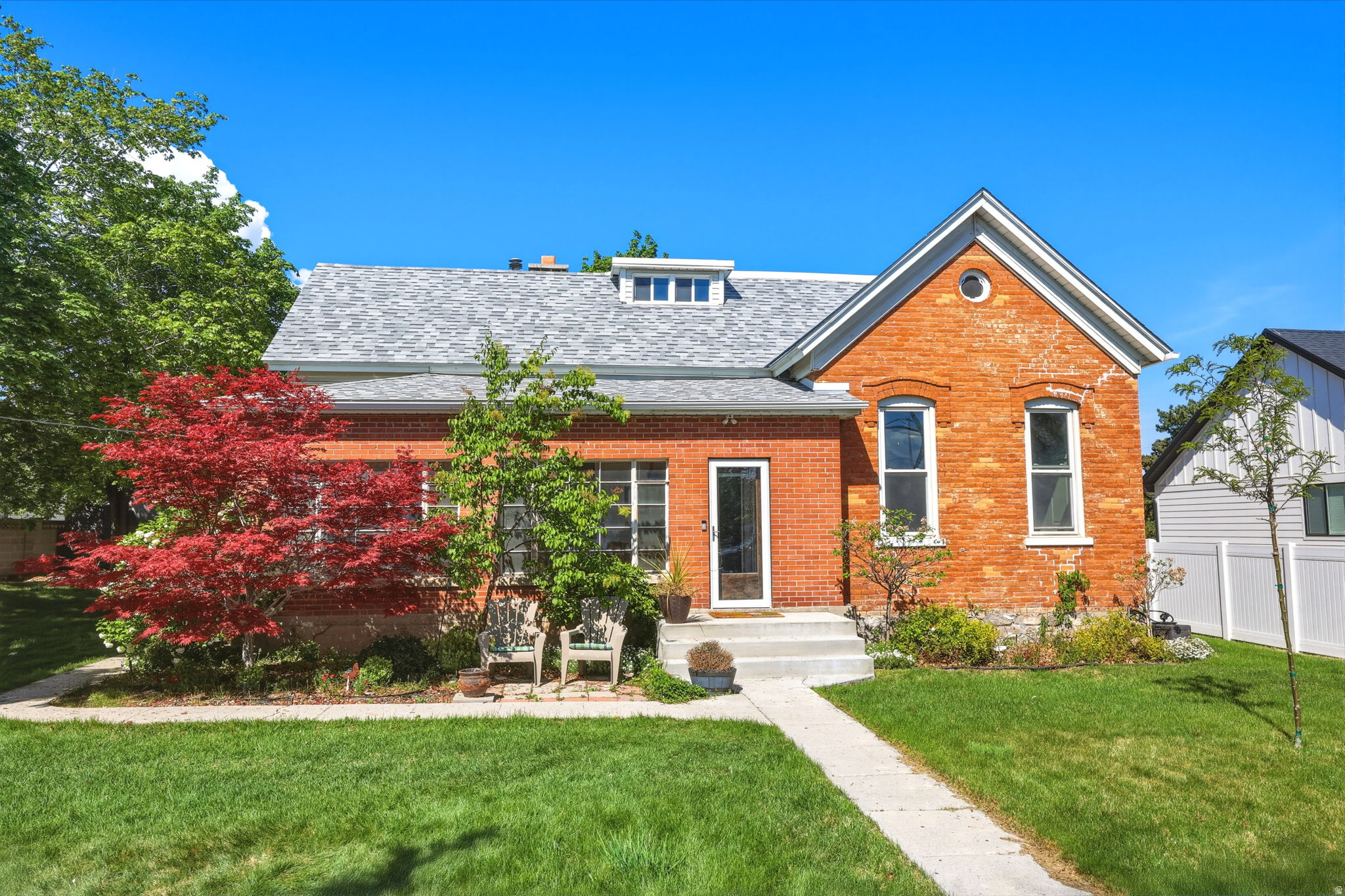 Turn-of-the-century farmhouse originally part of Newton Farms, built in 1895 and thoughtfully updated for modern living while preserving its character. Features include high ceilings, crown molding, a bright sunroom, and a spacious front room that flows into the kitchen and living area. The kitchen has been fully renovated with a large island, gas range, double ovens, breakfast nook, and dedicated coffee station. Just off the kitchen is a generous laundry room with abundant storage and large dining room. The main-level primary suite offers two closets. Recent updates include a new roof, porch, and gutters within the past year. The backyard is a private retreat with a storage shed, root cellar, and mature fruit trees including apple, Asian pear, peach, and black walnut, along with strawberry and raspberry bushes. The finished attic expands the living space with a full bathroom, living room and 4 additional bedrooms.