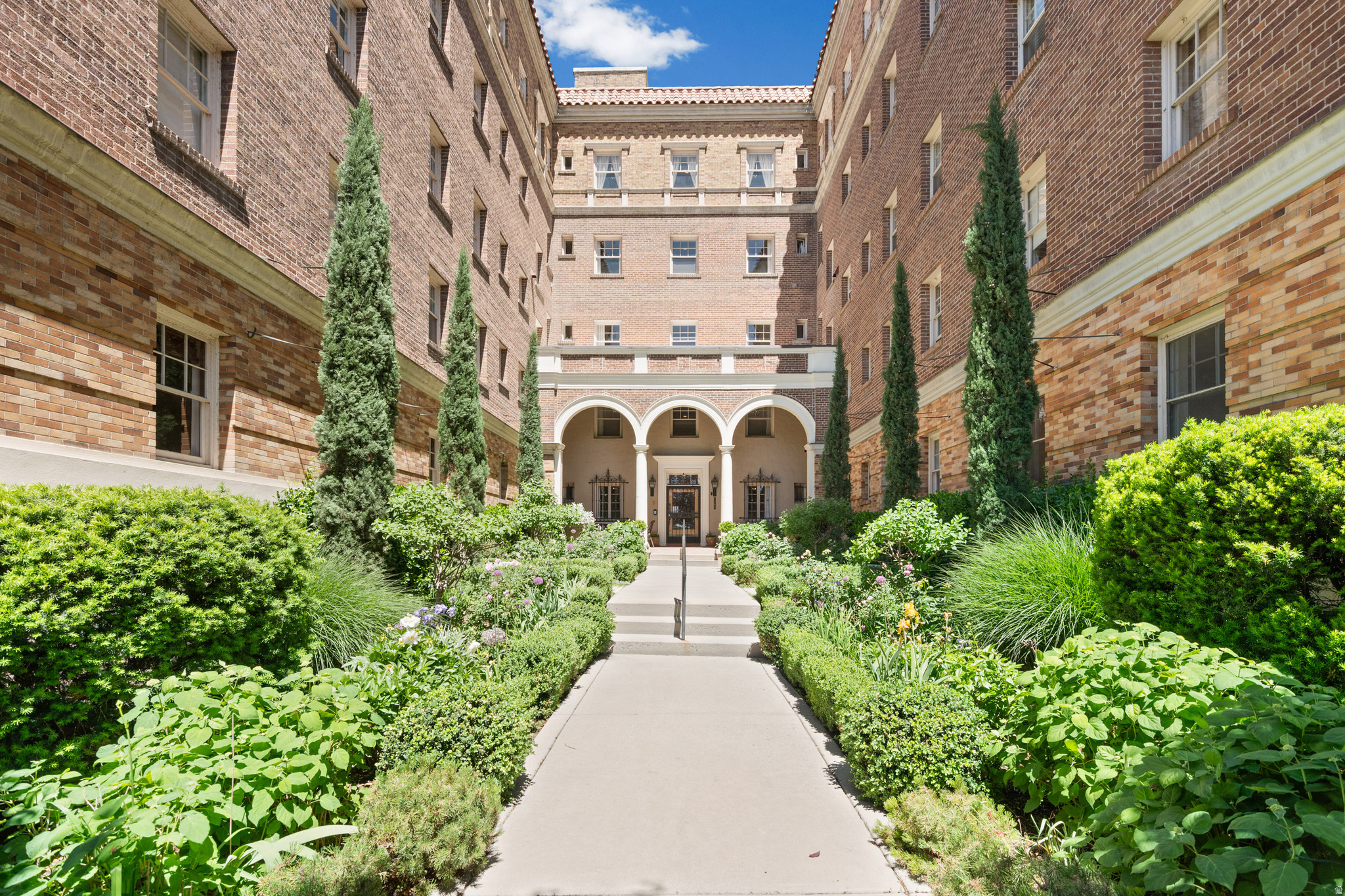 Welcome to refined urban living in one of Salt Lake City's most iconic historic buildings. Nestled along the tree-lined charm of South Temple, this spacious condo in the coveted Mayflower Building blends timeless character with an open, light-filled layout designed for modern living. Rich wood floors, expansive living spaces, and abundant natural light create an inviting atmosphere throughout.  The primary suite offers a rare adjoining library/office retreat-perfect for working from home, a private reading sanctuary, or creative space. Thoughtfully designed for both comfort and functionality, the home provides an effortless flow ideal for everyday living and entertaining alike. New Minisplit system brings comfort air controls to your fingertips, in this wonderful historic home.   Surrounded by beautifully maintained grounds and mature landscaping, residents enjoy a peaceful sense of serenity just moments from the energy of the city. Ideally located near The University of Utah, downtown dining, shopping, cultural attractions, and nearby parks, this residence offers the perfect balance of historic elegance, convenience, and quiet retreat in one of Salt Lake City's most established neighborhoods.  Square footage figures are provided as a courtesy estimate only and were obtained from County records and includes laundry room with 3/4 bath and storage room in basement.  Buyer is advised to obtain an independent measurement.