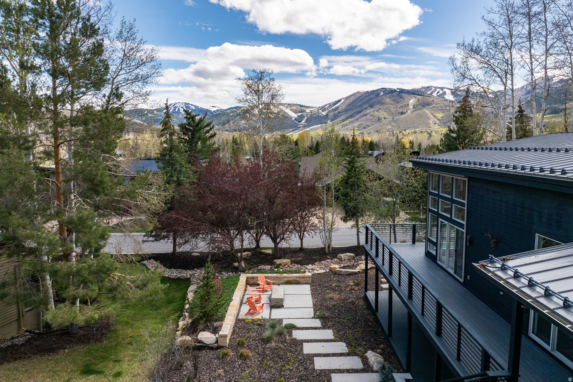 Experience effortless Park City living in this stylishly updated Park Meadows home with ski run views and exceptional indoor-outdoor flow. Designed for main-level living, the light-filled great room features soaring 14-foot ceilings and walls of glass that frame the mountains. The chef's kitchen, complete with Thermador appliances, double dishwashers, wine refrigeration, and a walk-in pantry, opens seamlessly to an inviting den and expansive deck, ideal for entertaining or quiet evenings under the stars. The main-level primary suite offers Deer Valley views, a fireplace, spa-like bath, and a generous closet with integrated workspace. Downstairs, four bedrooms, a wet bar, and gathering spaces create the perfect setting for hosting family and guests. Enjoy a beautifully landscaped, private yard with bocce court, firepit, and fenced dog run. Central air, a flat driveway, and an oversized 3-car garage complete this turnkey retreat just minutes from skiing, trails, and Historic Main Street.