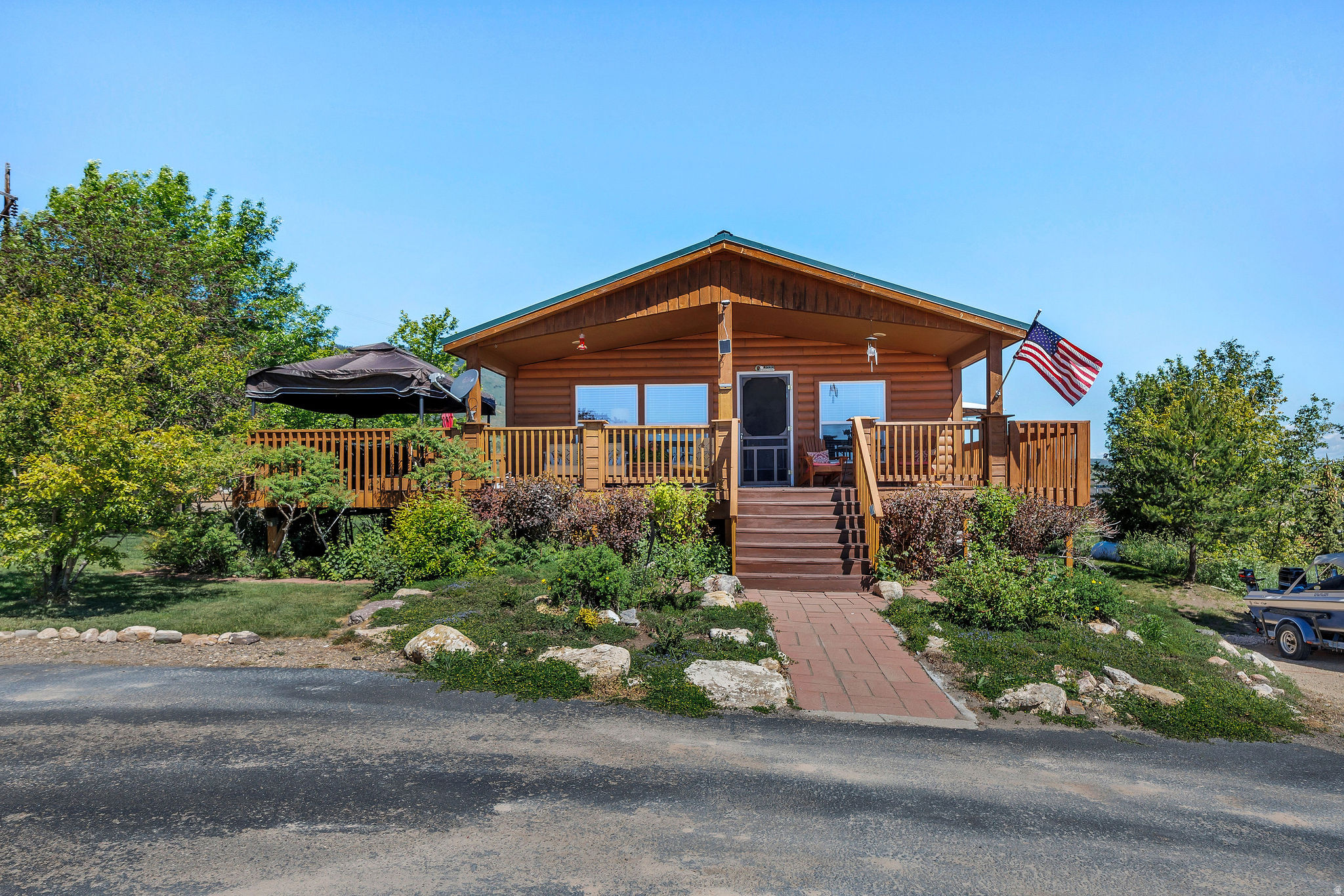 Enjoy the beauty and tranquility of Bear Lake living in this well-maintained manufactured home overlooking the sparkling waters of the lake. Whether you're seeking a peaceful year-round residence, a weekend retreat, or a retirement haven, this property offers comfort, convenience, and spectacular scenery.  Step inside to find a bright and welcoming floor plan featuring spacious living areas and abundant natural light.  The comfortable open concept living room, kitchen and dining area provide the perfect setting for everyday living and entertaining family and friends.  There is a finished basement with a family room, two additional bedrooms and a bathroom.  The oversized garage offers room for storage.  Outside, you'll love relaxing on the wrap around deck and enjoying the landscaped yard. The property offers a peaceful atmosphere with easy access to boating, fishing, hiking, and other outdoor recreational opportunities.  Don't miss this opportunity to own an affordable piece of lakeside paradise. Schedule your showing today and discover the lifestyle you've been dreaming about!  Square footage figures are provided as a courtesy estimate only and were obtained from the assessor's office and seller estimate for the basement area.  Buyer is advised to obtain an independent measurement.
