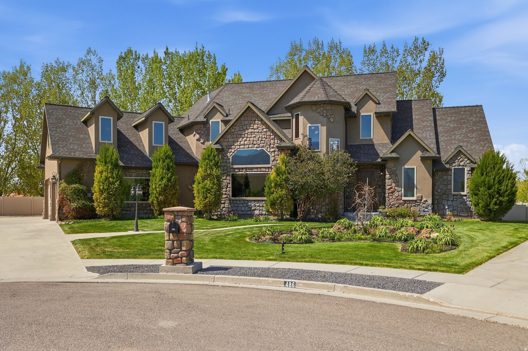 Welcome to this exquisite custom-designed residence nestled in a premier, high-end neighborhood, where thoughtful craftsmanship and timeless elegance meet everyday comfort. From the moment you arrive, the home's striking curb appeal, mature landscaping, and quiet cul-de-sac setting create a warm and inviting first impression. Inside, you'll find a beautifully curated floor plan designed with both functionality and grandeur in mind. Expansive vaulted ceilings and a stunning central fireplace anchor the main living space, while large windows invite in natural light and showcase the seamless indoor-outdoor connection. The chef's kitchen is a true centerpiece, featuring granite countertops, double wall ovens, and a commercial-size refrigerator/freezer-perfect for both daily living and entertaining. Main-level living offers convenience and ease, highlighted by spacious bedrooms, generously sized bathrooms, and a large, well-appointed laundry room. Just off the garage, a versatile storage room provides the perfect space for organization or even recreational gear. The attached shop adds exceptional flexibility for hobbies, projects, or additional workspace. The fully finished basement is designed for entertaining and relaxation, complete with a stylish wet bar and a dedicated theater room featuring seating, projector, screen, and components included. A walk-out basement provides direct exterior access and enhances the home's open, flowing layout. Step outside to enjoy a large covered patio, ideal for year-round gatherings, overlooking a fully fenced backyard with lush, mature landscaping-offering both privacy and beauty. Additional features include dual HVAC systems for improved efficiency, pre-plumbing for central vacuum, and electrical readiness for a backup generator-reflecting the careful planning and quality invested throughout. This home is a rare blend of sophistication, comfort, and thoughtful design-truly a standout property in an exceptional location. Buyer to verify all information. Be sure to click on the 3D tour for the interior floor plan and video tour. Property shown to pre-approved and qualified buyers only. 24 Hour notice for all showings.