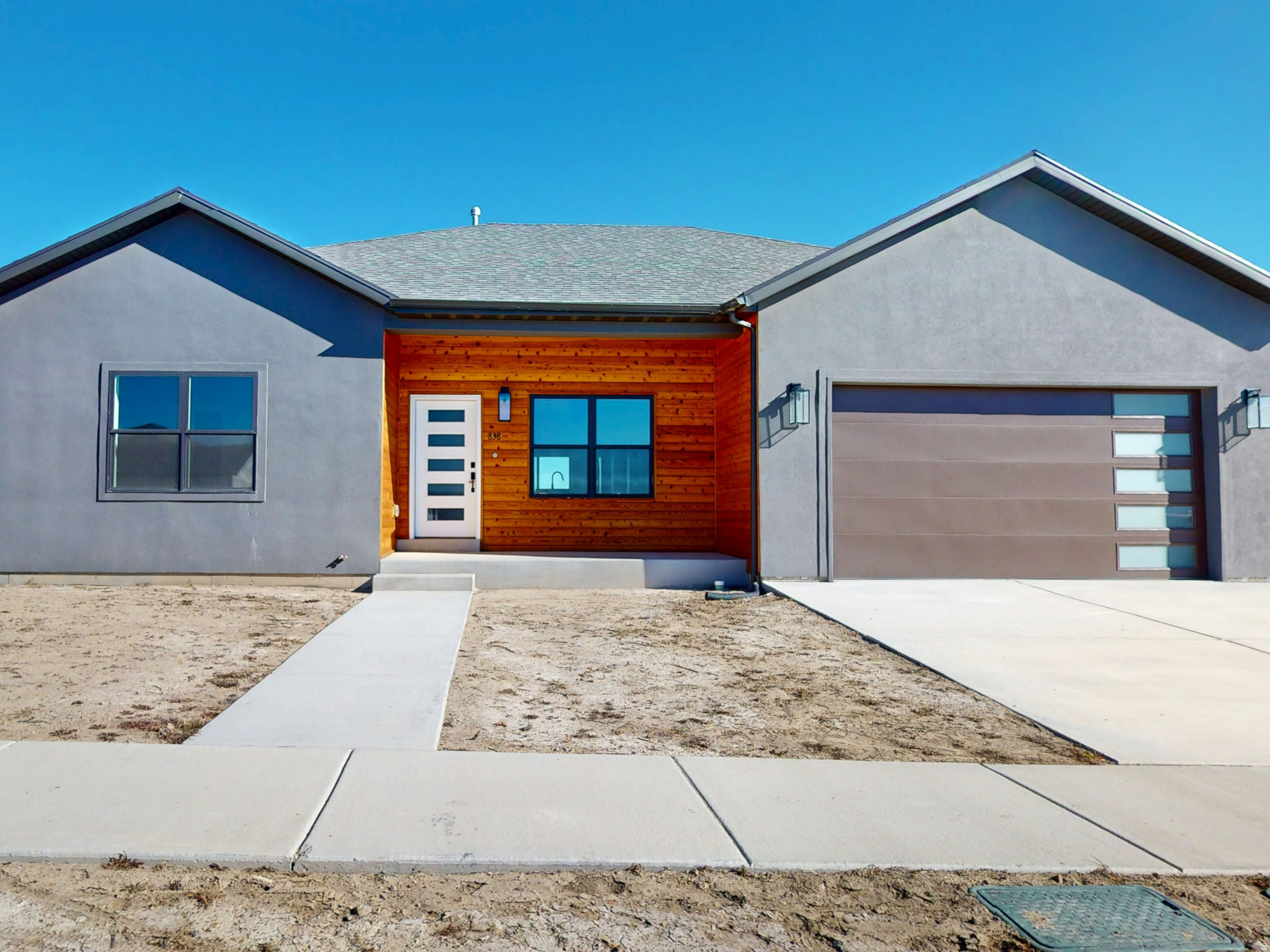 Discover the epitome of contemporary living with this stunning single-level new construction home, featuring a sleek modern style accentuated by dark finishes and brush nickel fixtures. This spacious abode offers three bedrooms, two bathrooms, and a two-car garage, ensuring ample space for your family and vehicles. Both bathrooms boast double sinks for added convenience. The kitchen is a chef's dream with all-new G.E. stainless steel appliances, Corian countertops, a farm-style sink, and a special cabinet for your kitchen wastebasket. Storage is plentiful with closet organizers and a generous pantry. The luxurious master bedroom and dining room both provide direct access to the inviting back patio, perfect for outdoor relaxation. Additionally, the home is plumbed for a water softener and includes garage electric outlets to accommodate electric vehicles, ensuring modern amenities are at your fingertips. first-time buyers may qualify with a $20,000 grant available on this home, which can be used for Closing costs or down payment, ask your agent for more details.